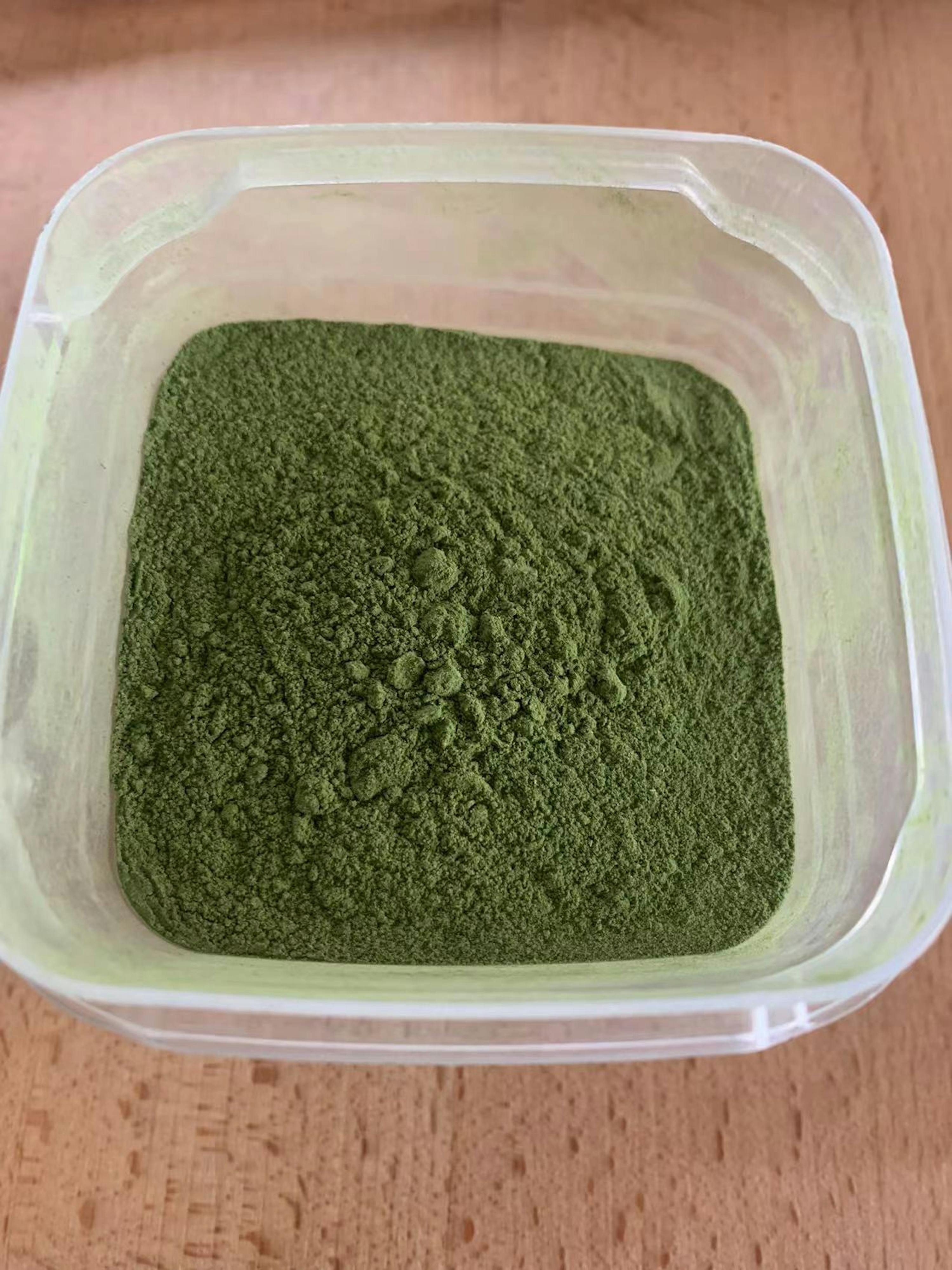 une boîte en plastique remplie de poudre verte