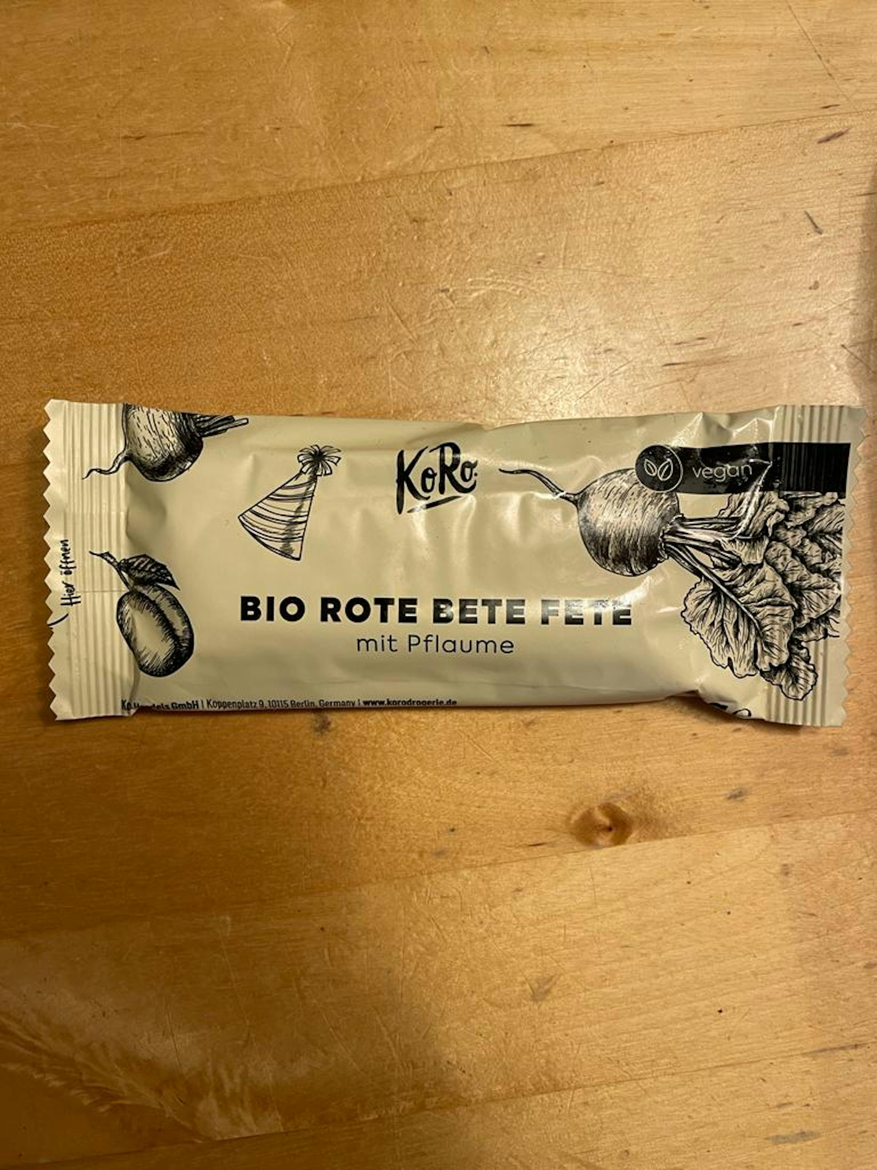 un paquet de kore bio rote eete fete mit pflaume est posé sur une table en bois
