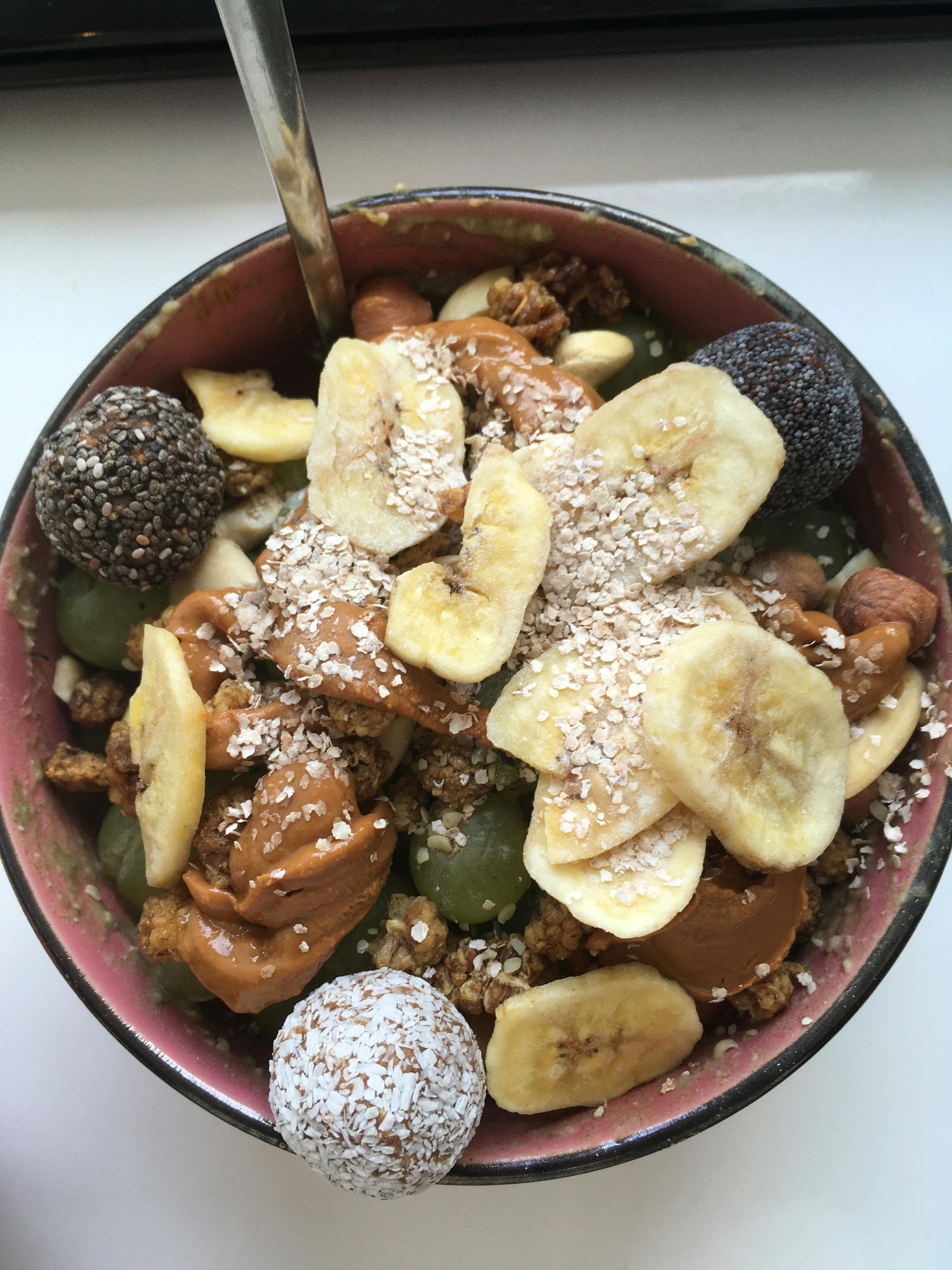 eine rote und schwarze Schüssel mit Bananen , Nüssen und Müsli