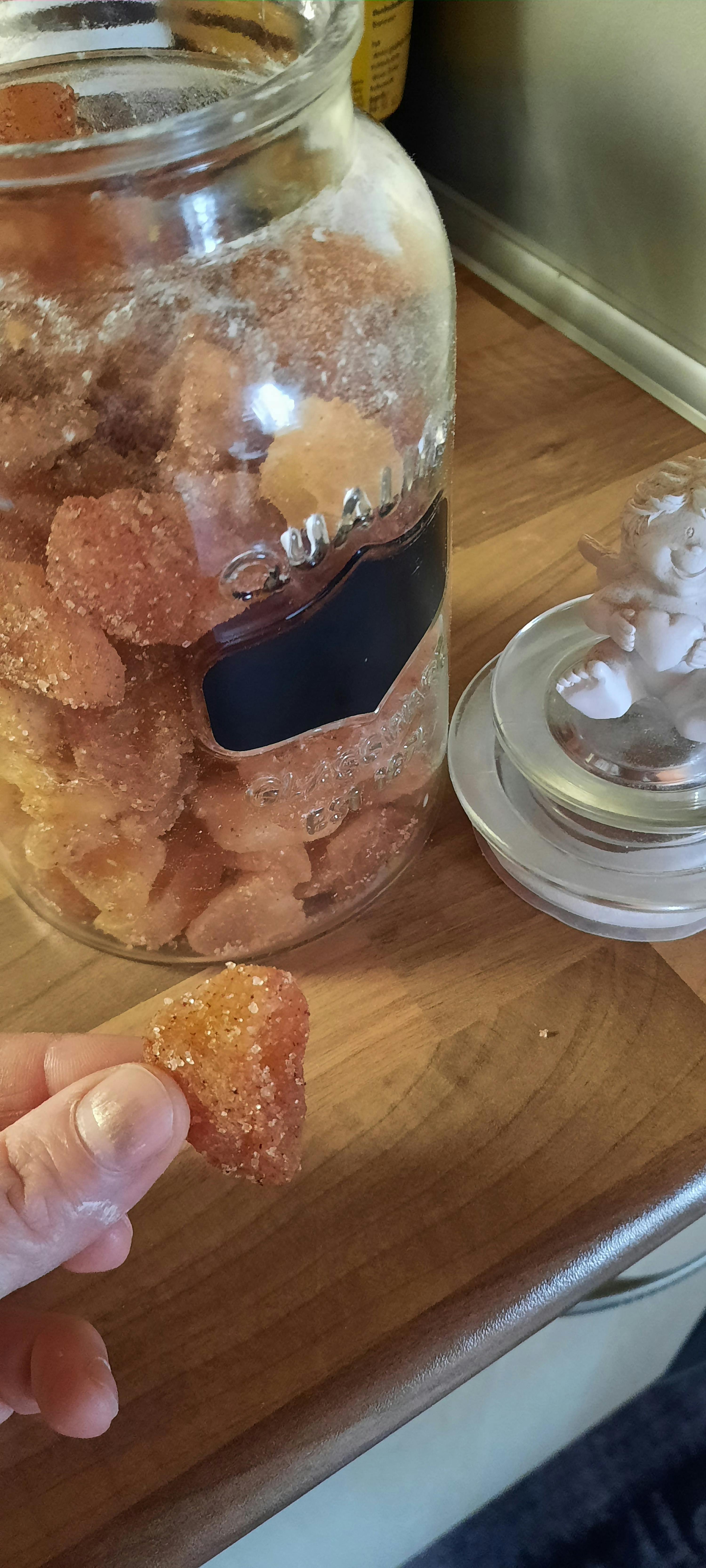 un bocal en verre rempli de bonbons est posé sur une table en bois