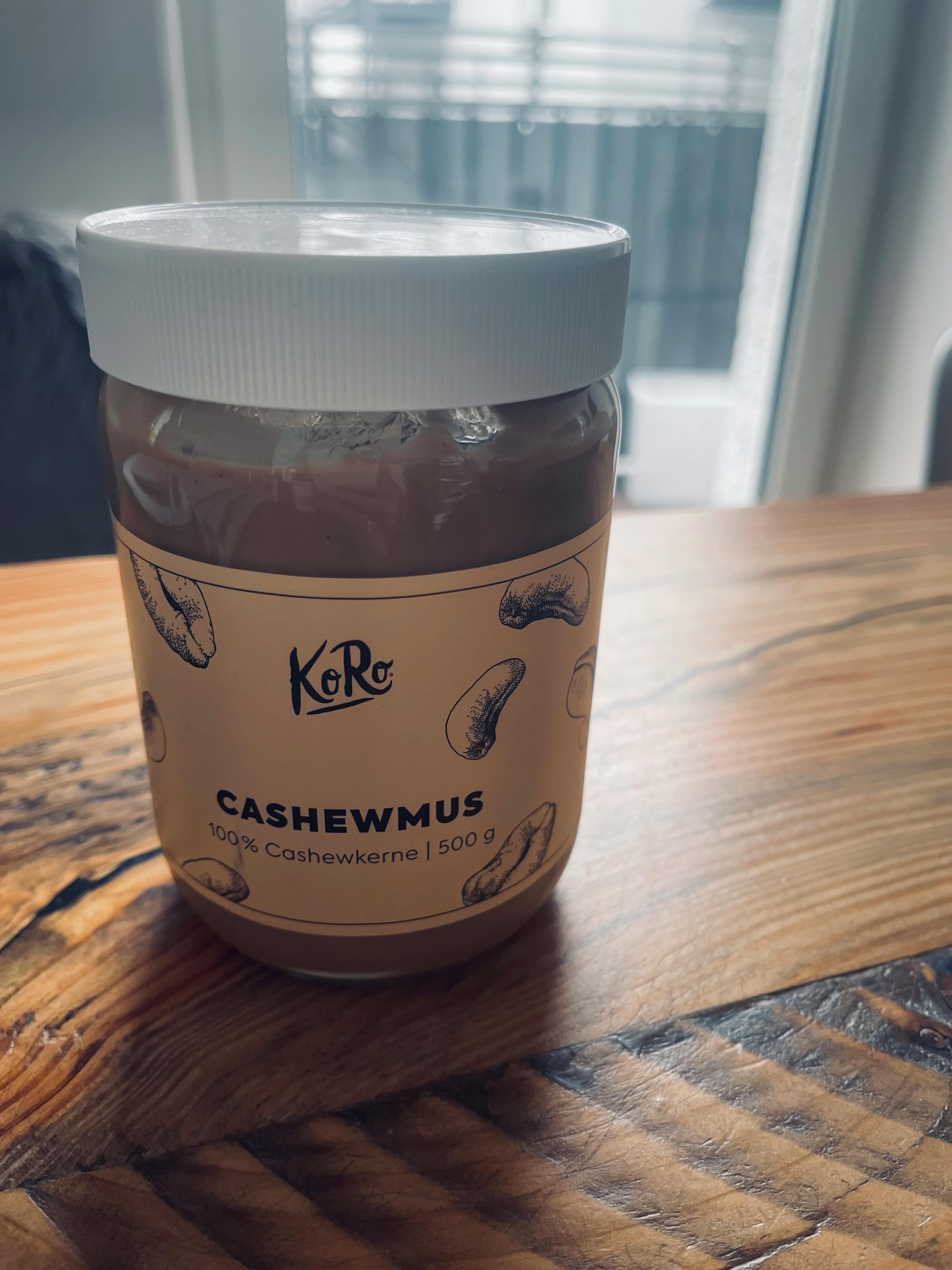 a jar of cashewmus is on a wooden table