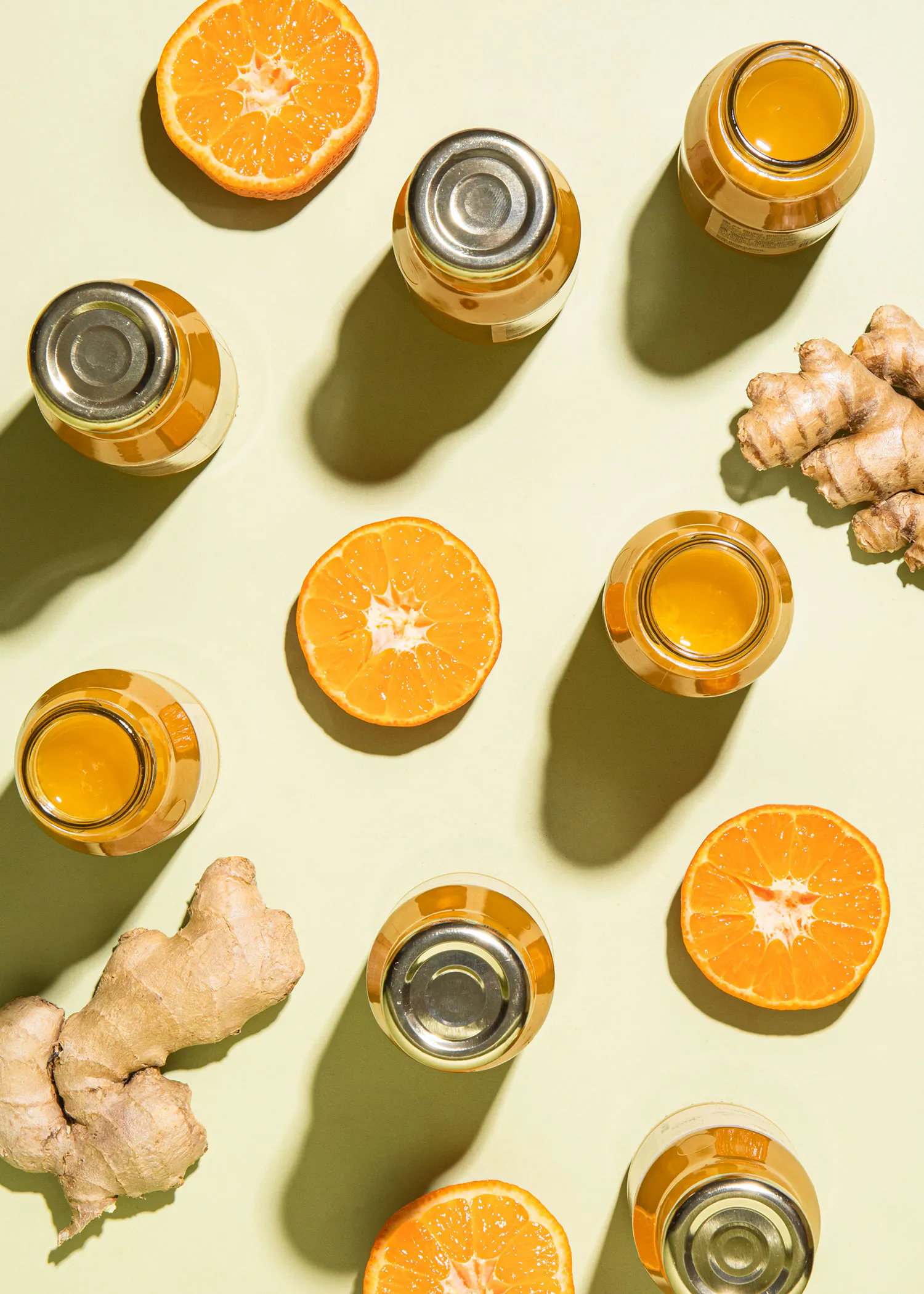 naranjas y jengibre junto a botellas de jugo y miel