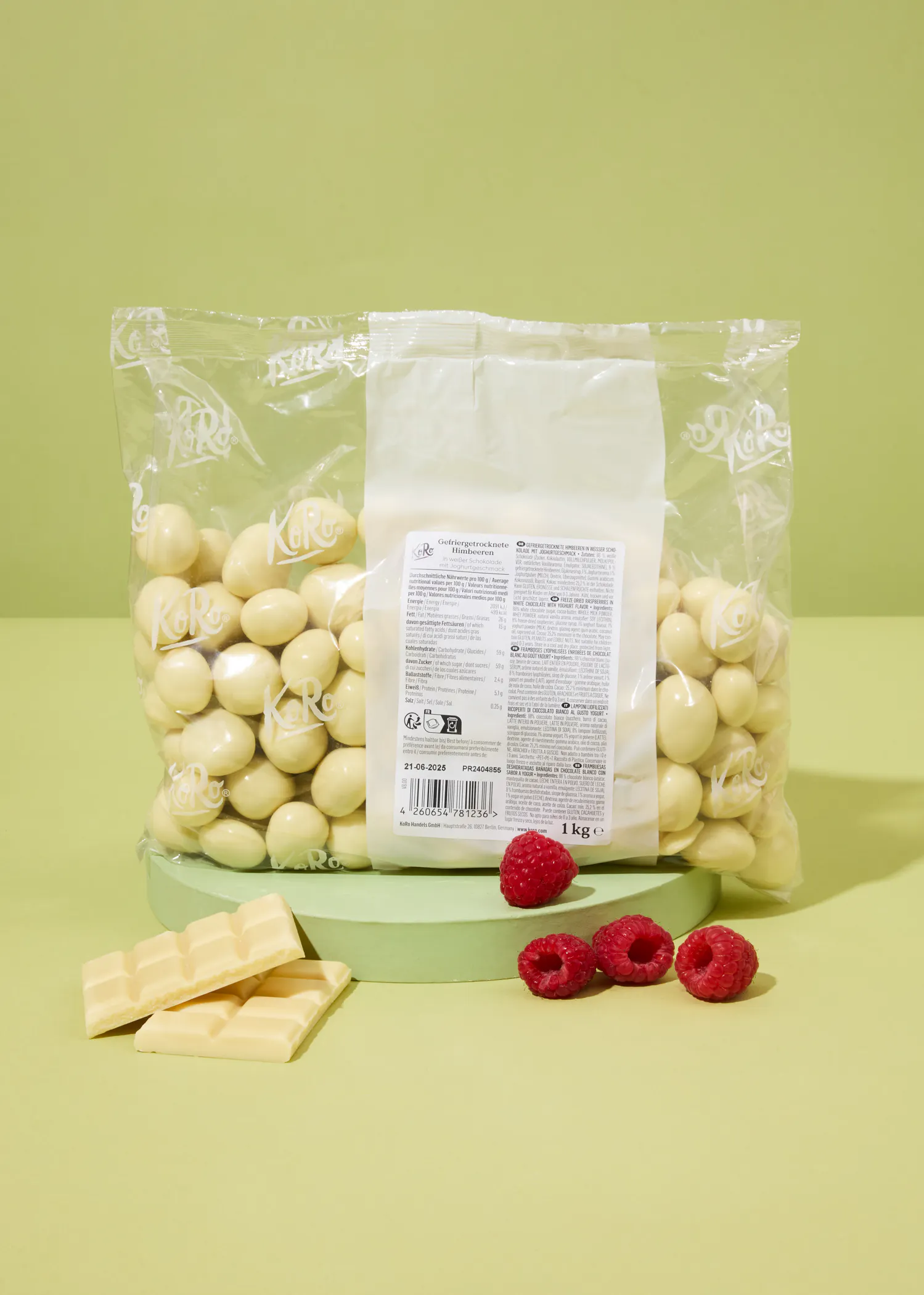 un sac de chocolat blanc est assis sur une table avec des framboises