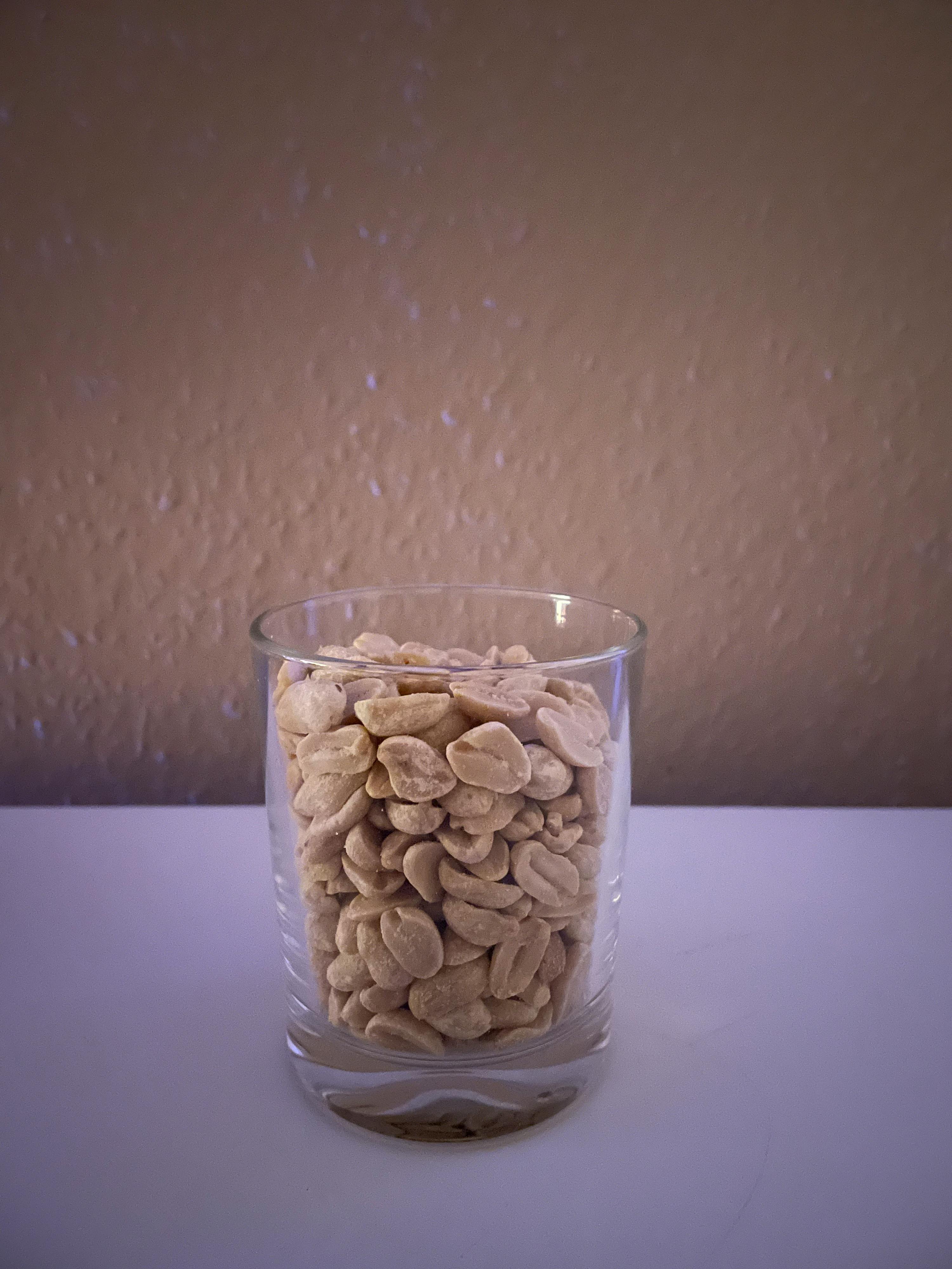un verre rempli de cacahuètes est posé sur une table