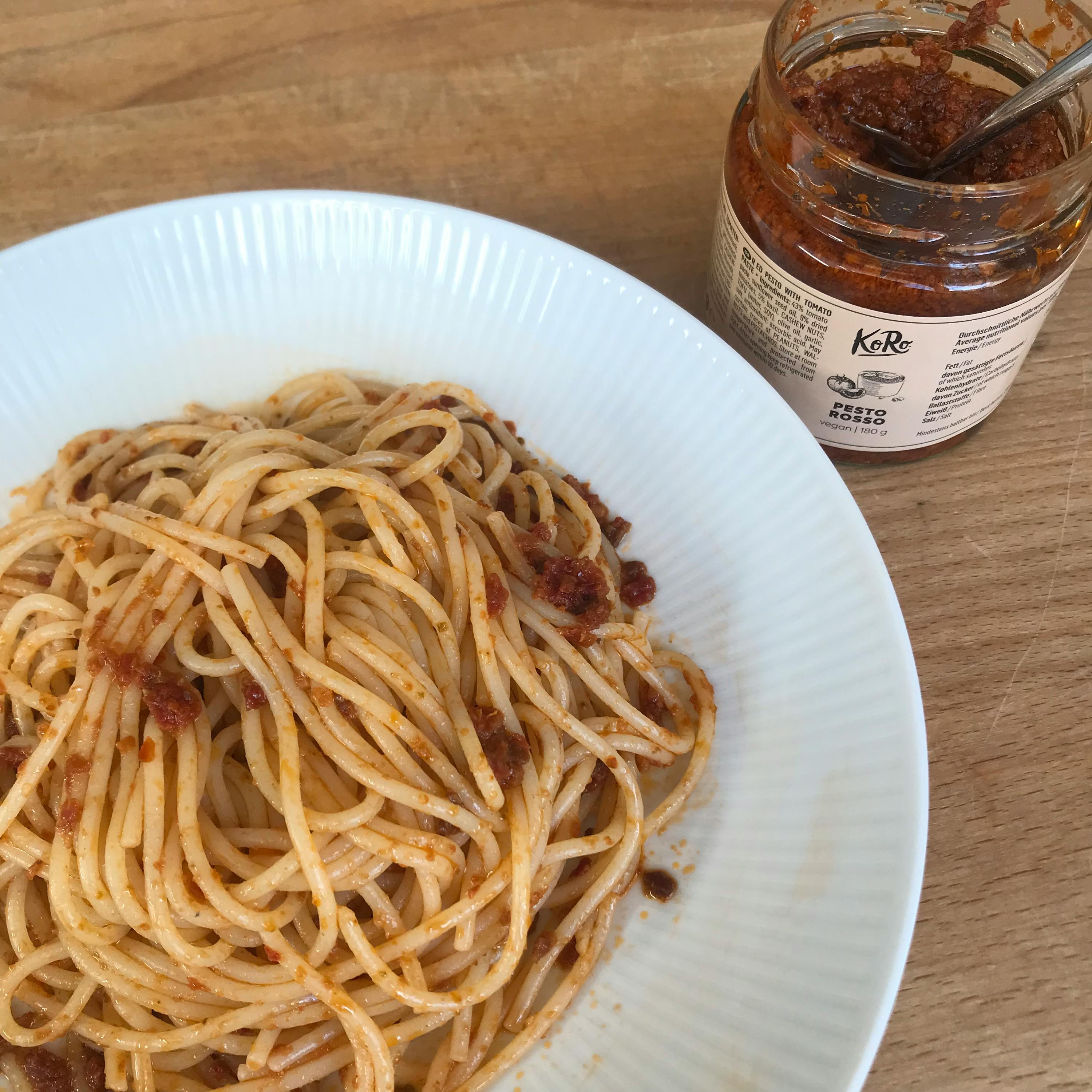un piatto di spaghetti è seduto accanto a un barattolo di kr