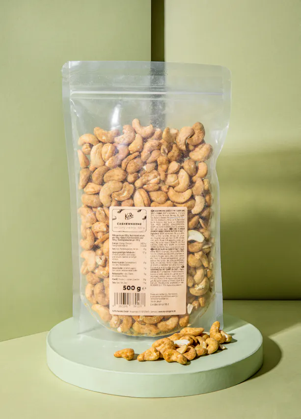 un sac de noix de cajou est assis sur une table verte