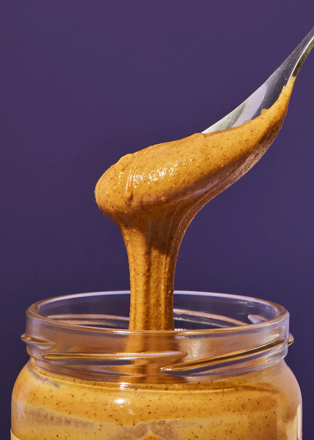 eine Schüssel Erdnussbutter wird aus einem Glas gegossen