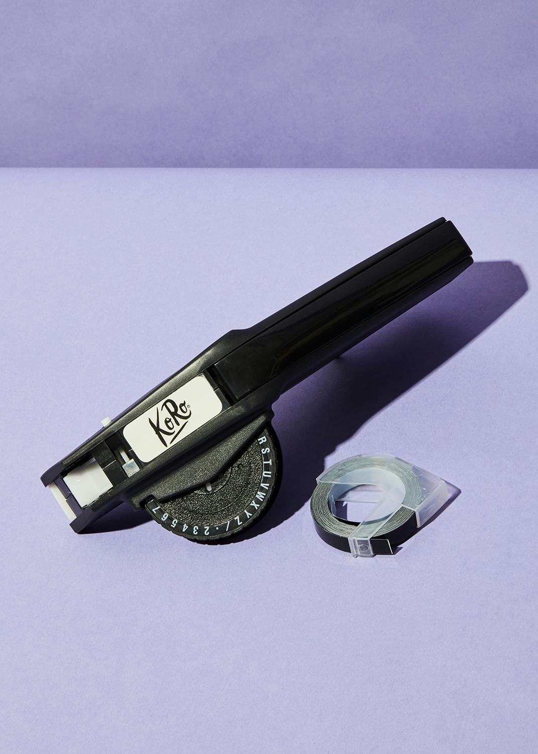 Etiqueteuse manuelle une machine à étiqueter kate est assise sur une surface violette