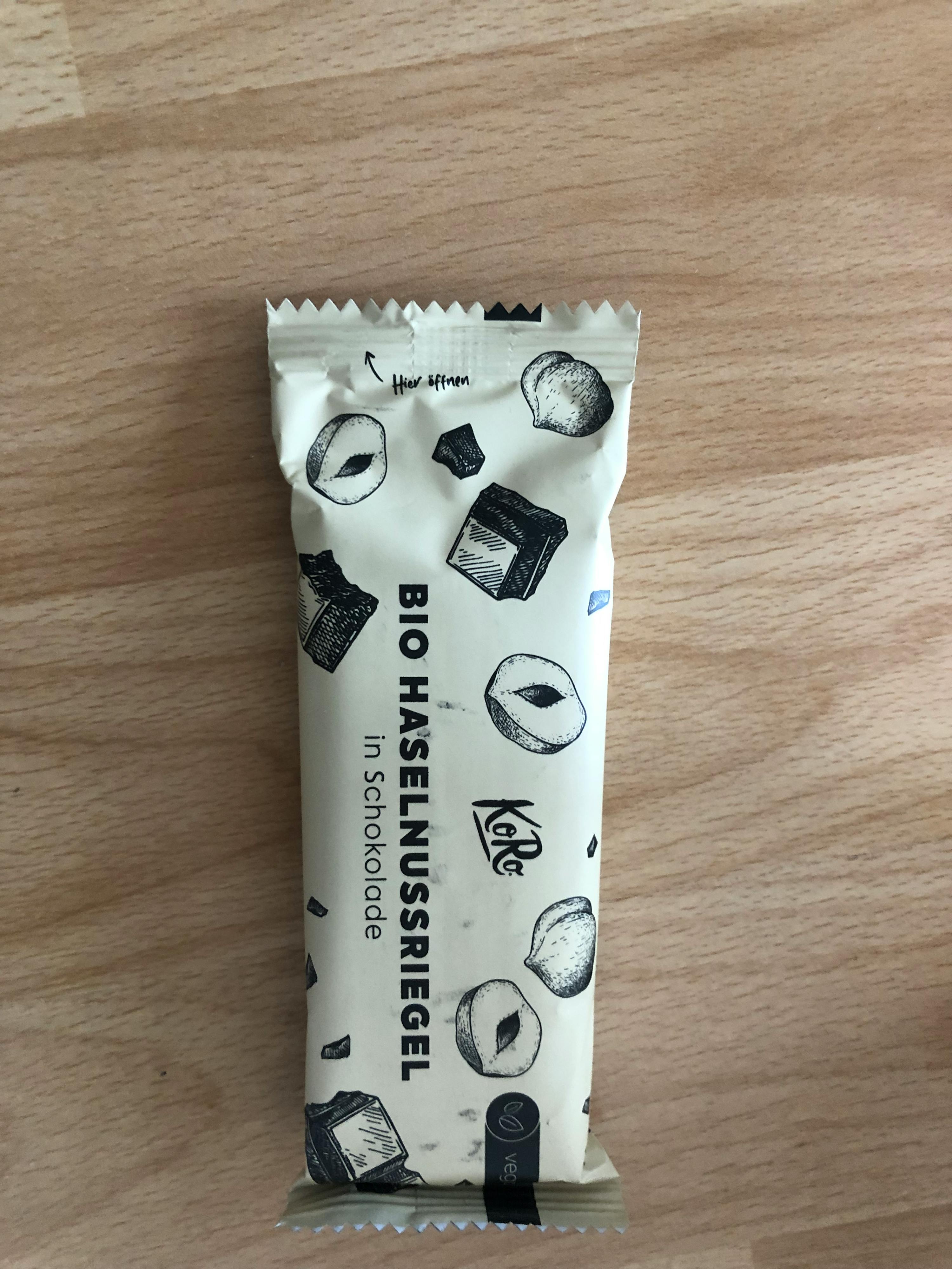 une barre de chocolat bio haselnussriegel in schokolade est posée sur une table en bois