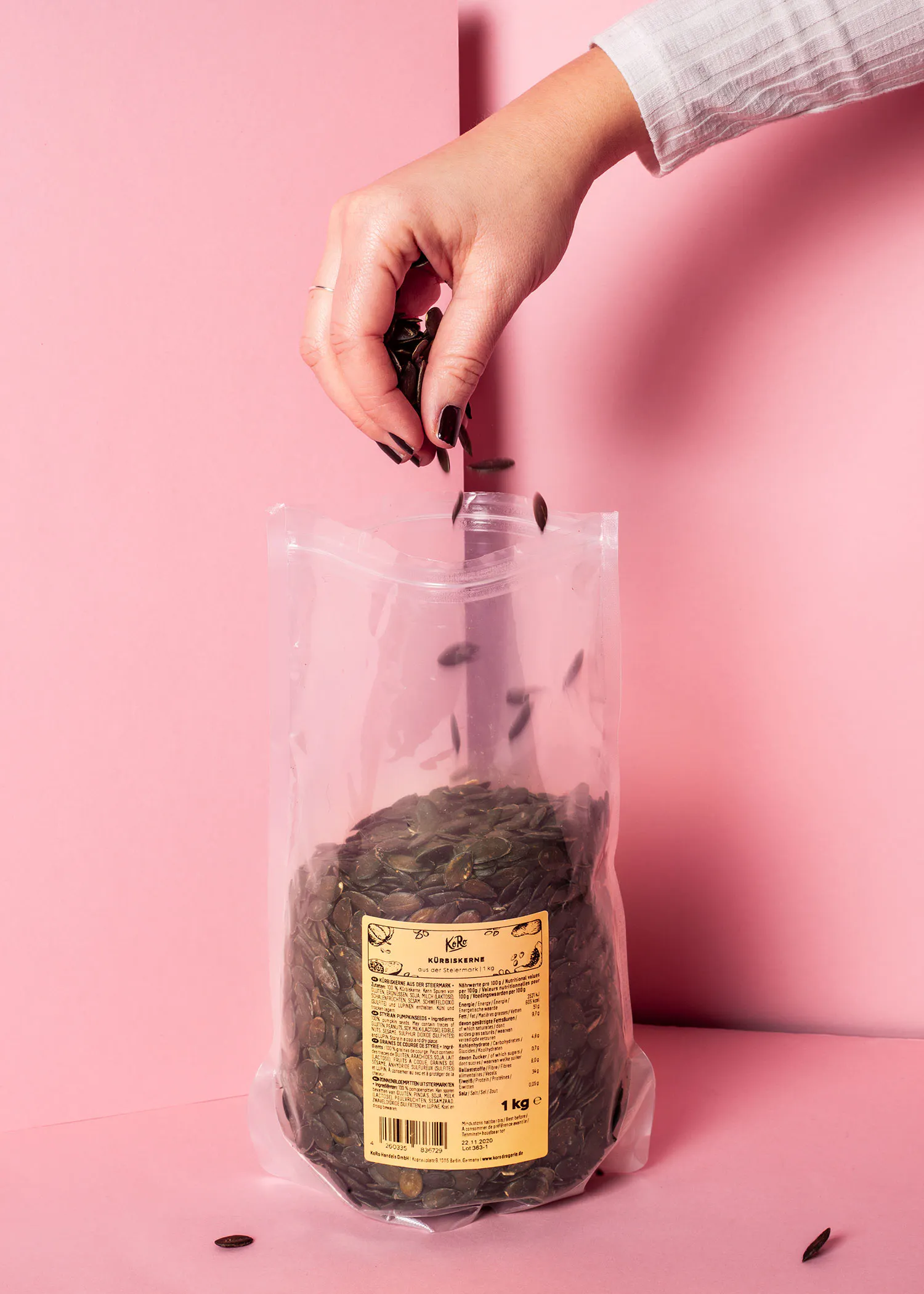 une personne remplit un sac de graines de citrouille