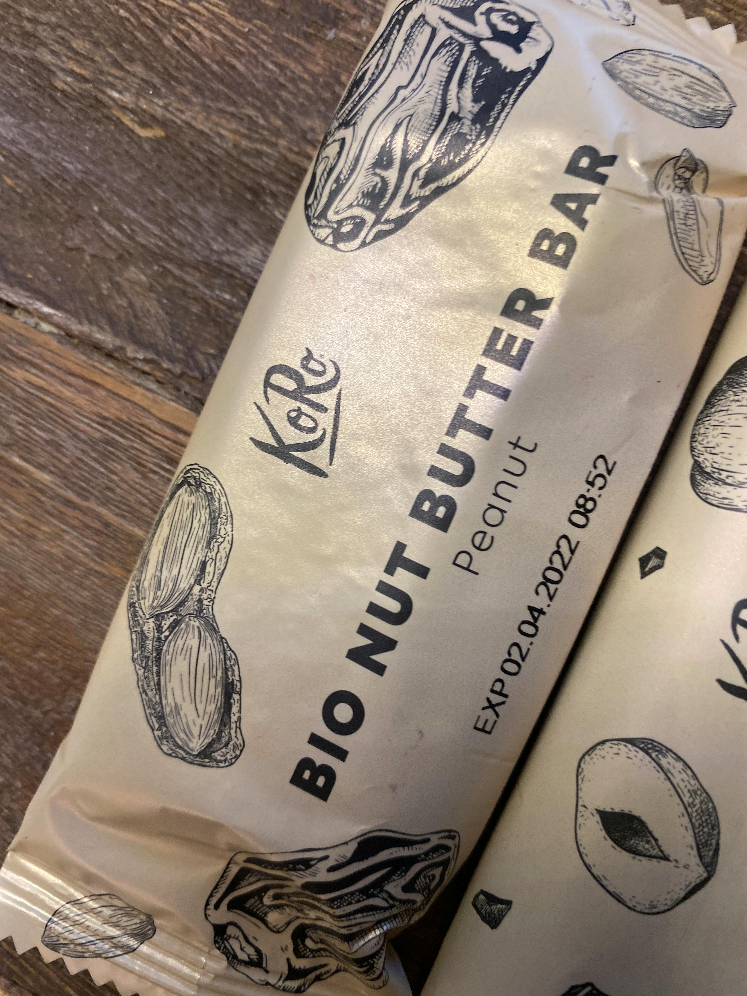 eine verpackte Bio-Nougatbutter-Bar liegt auf einem Holztisch