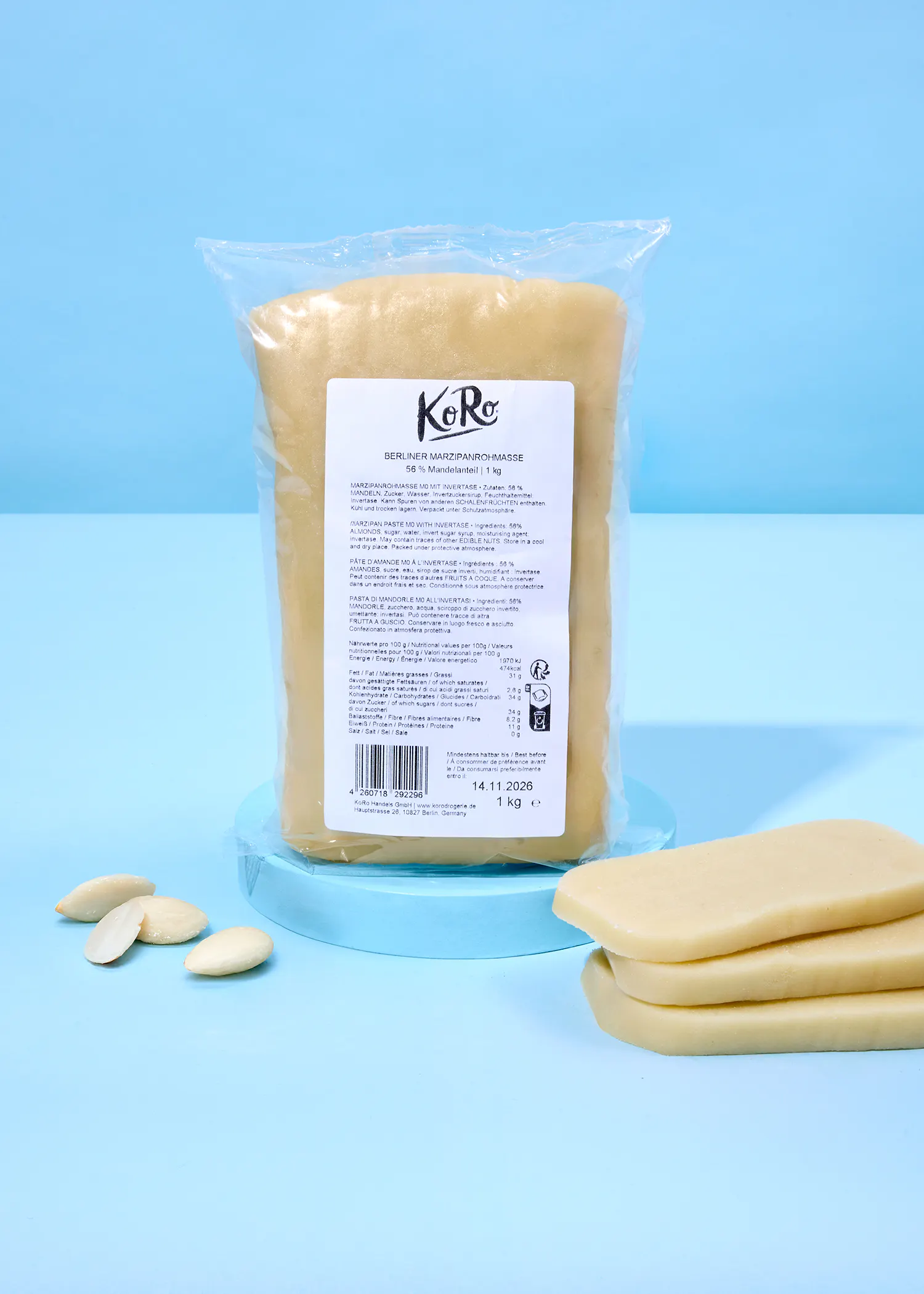 ein beutel berliner marzipanrohmasse mit 56% mandelanteil und 1 kg gewicht, daneben liegen einige stücke marzipan und mandeln.