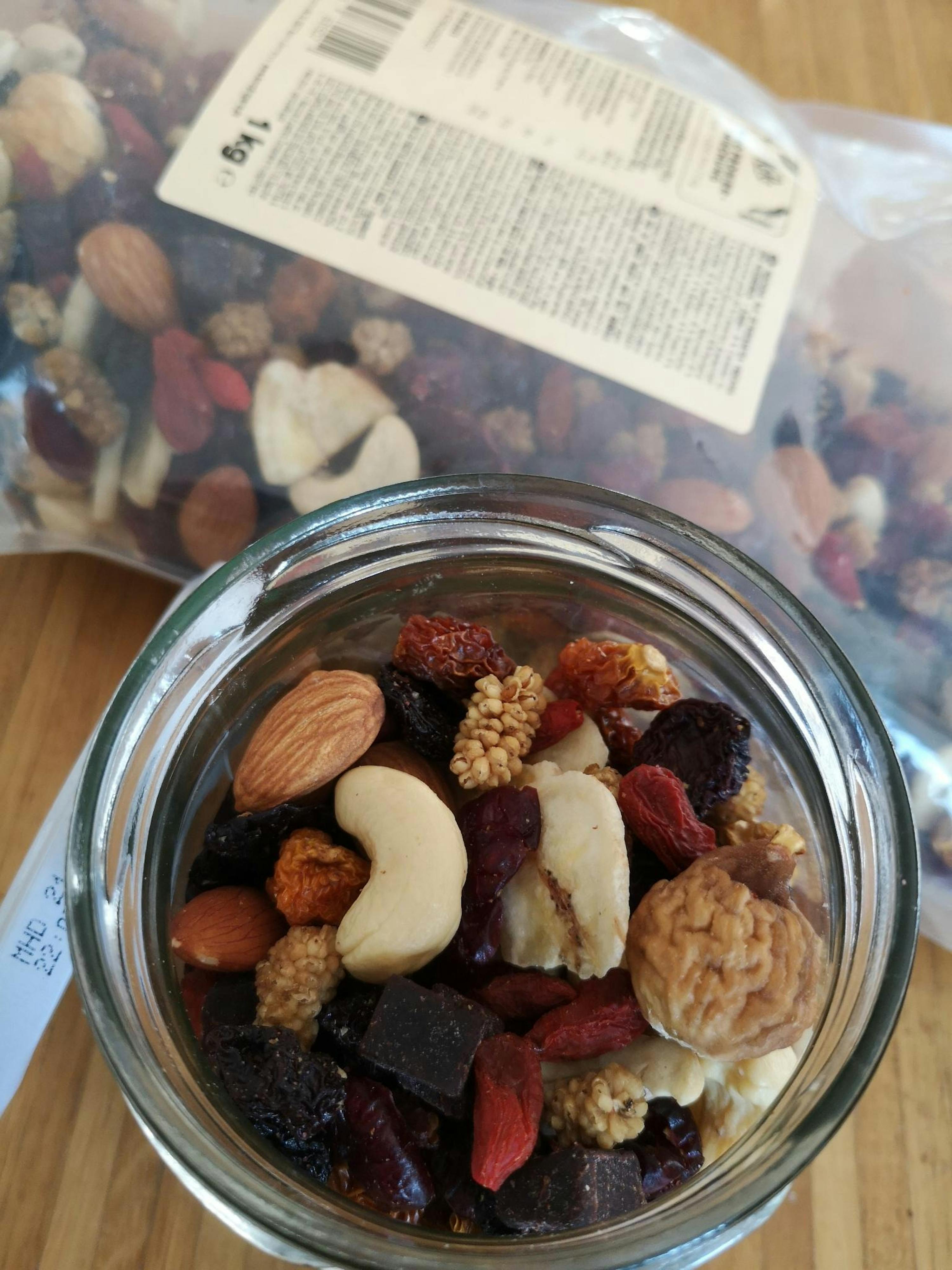 eine Glasschale mit einer Mischung aus Nüssen und Früchten