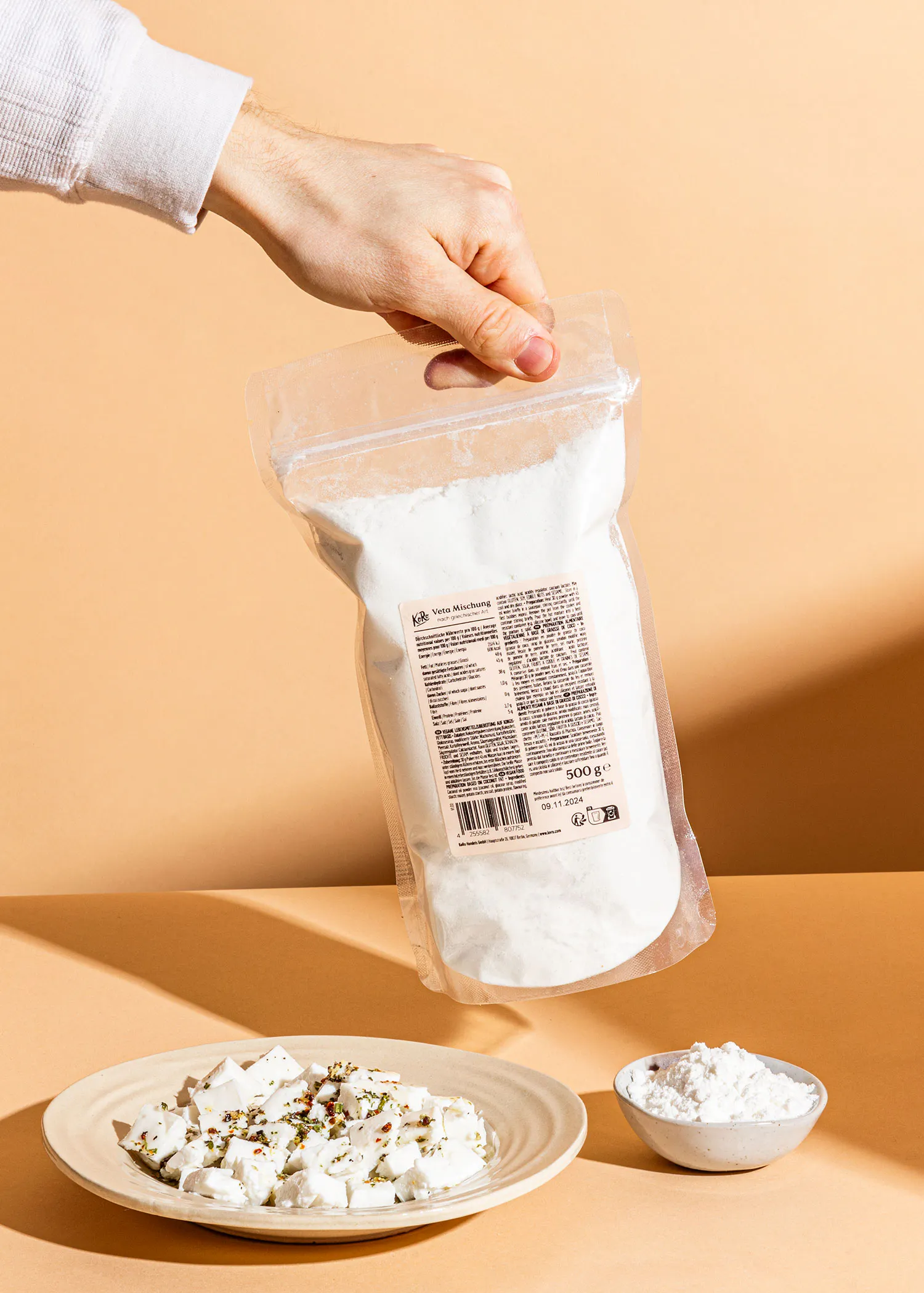 une personne tient un sac de farine blanche à côté d' une assiette de nourriture