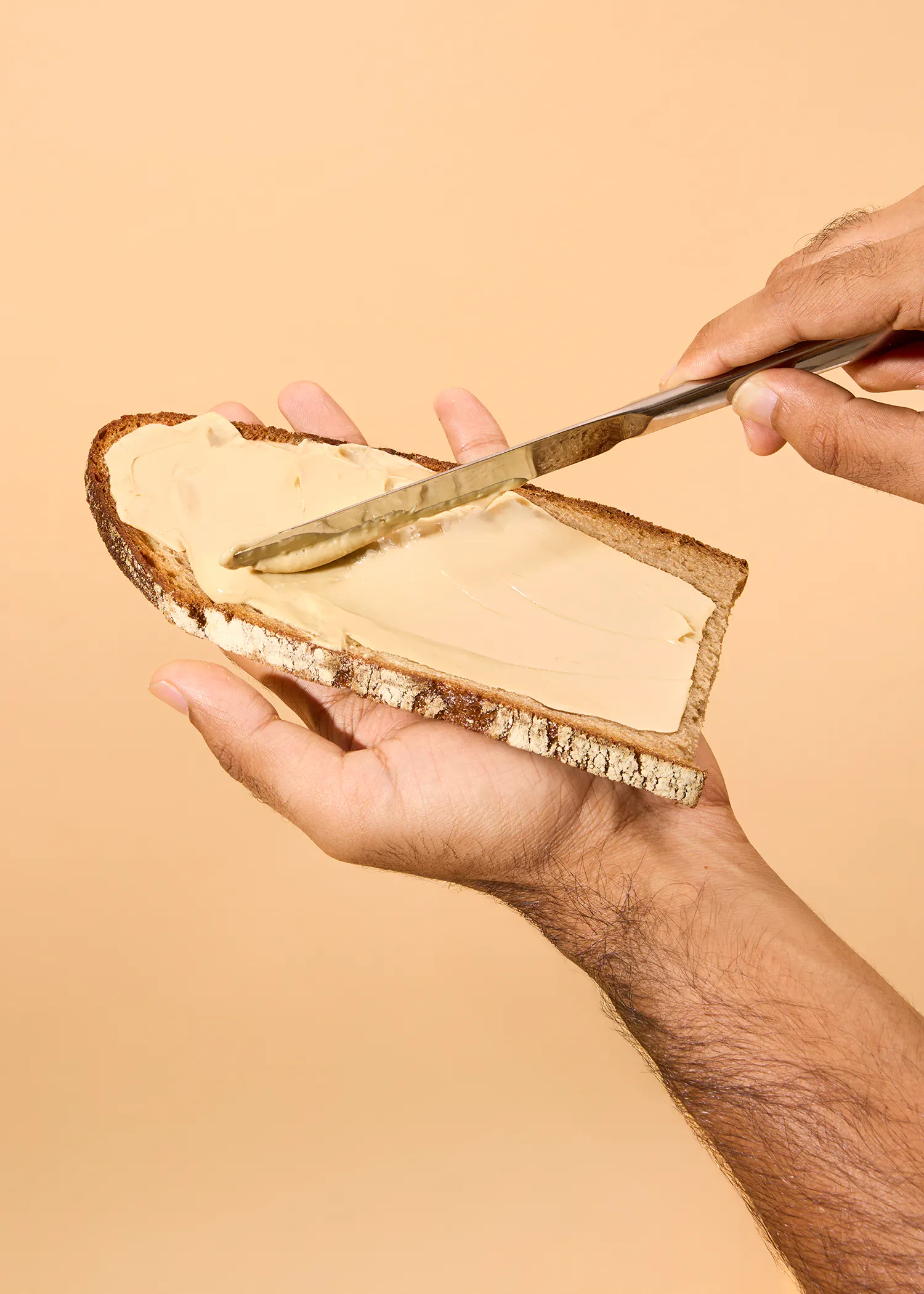 a person is spreading butter on a piece of bread