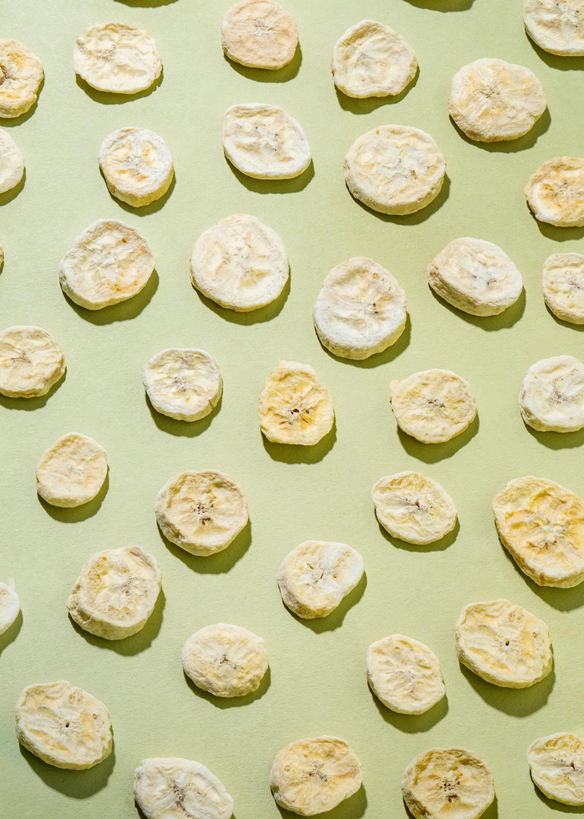 a pattern of banana chips on a green surface