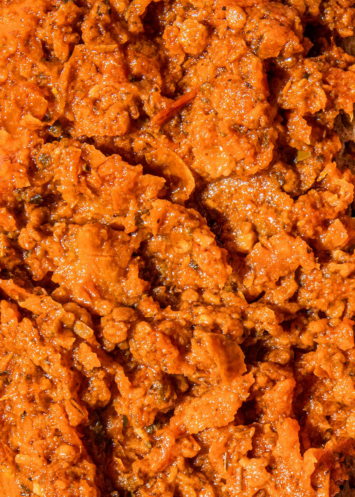 Roasted tomato spread 1kg a close up of a sauce with a few pieces of meat in it