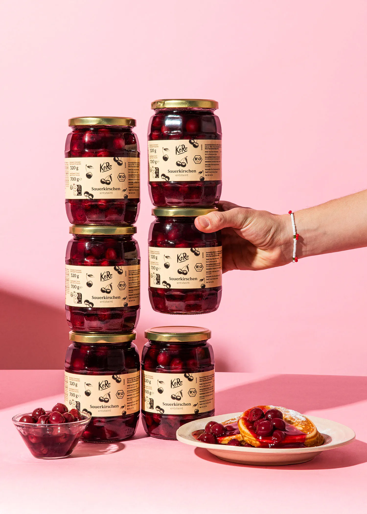 six bocaux de kirbe sont empilés les uns sur les autres sur une table rose