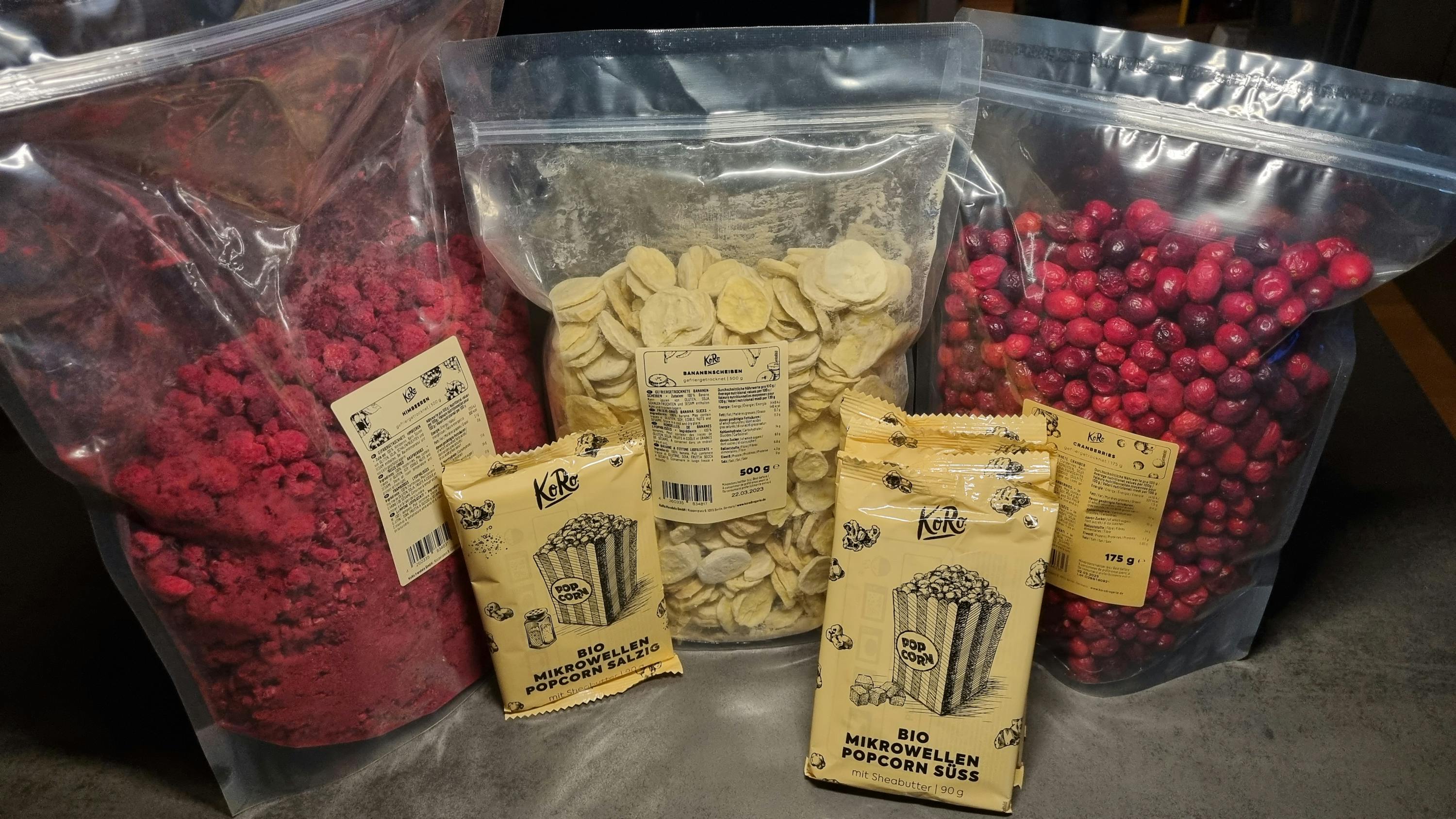 a bag of bio mini-wellen popcorn suss sits next to a bag of cranberries