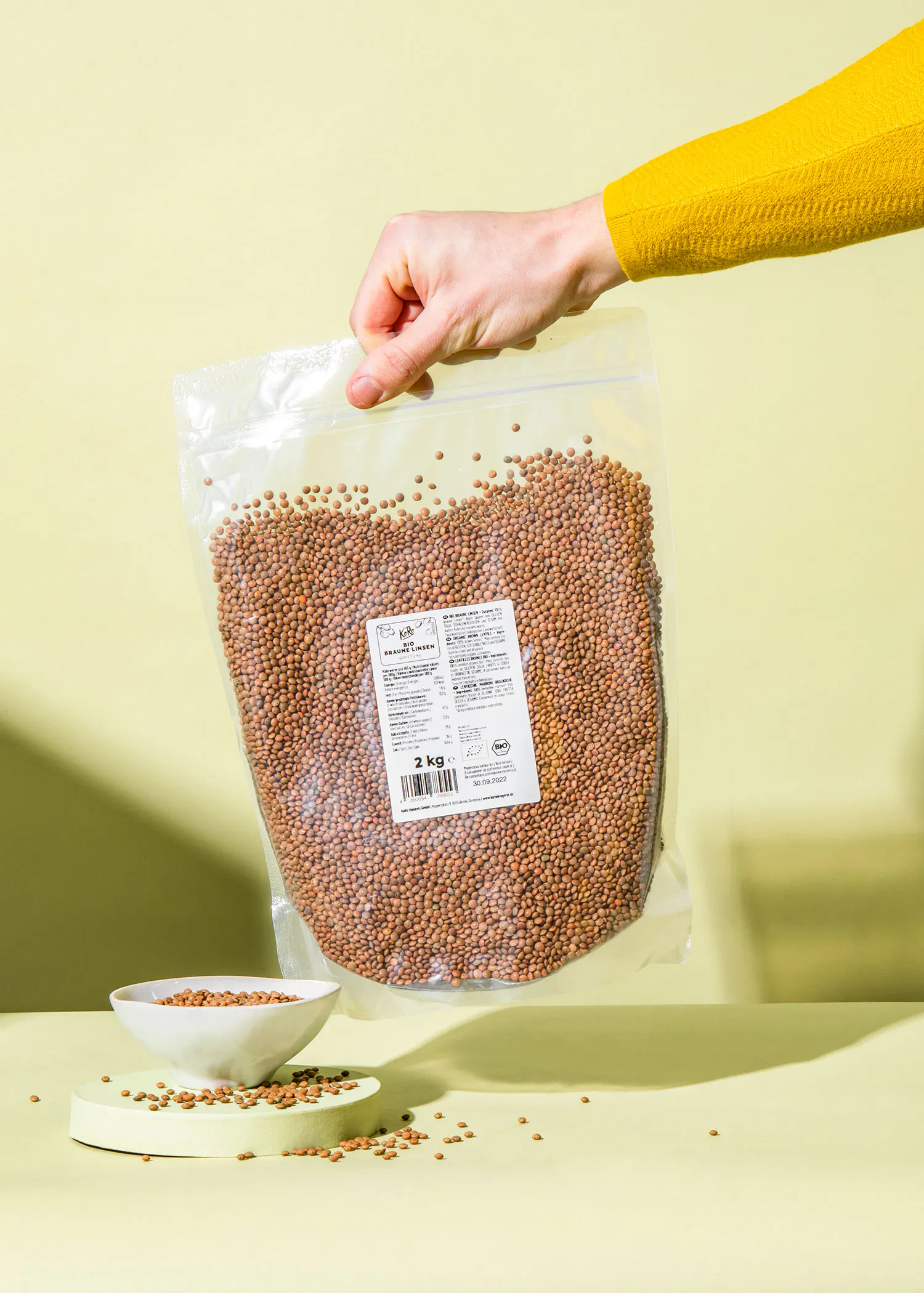 a person is holding a bag of 2 kg beans