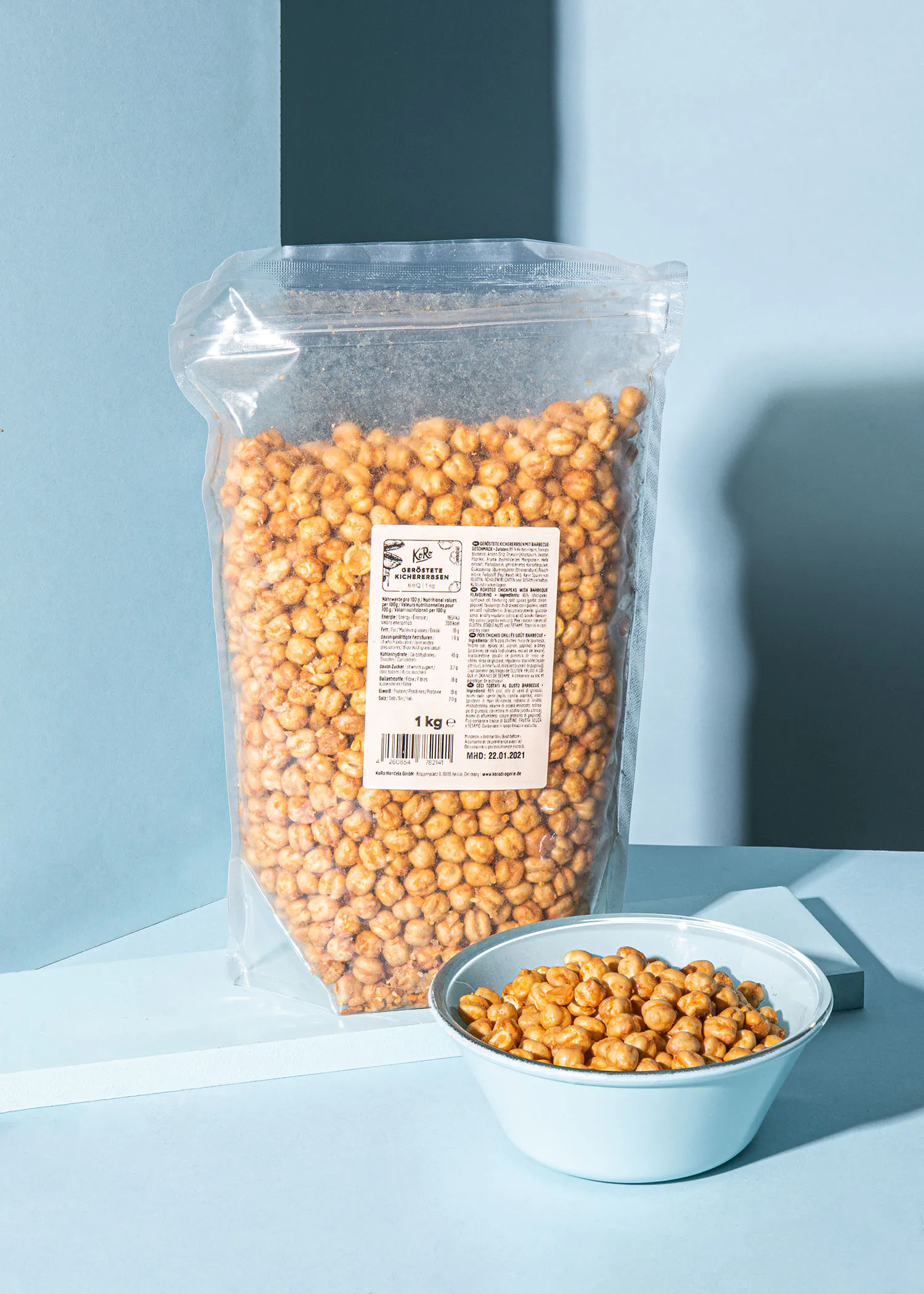 eine Tüte gesalzener Erdnüsse neben einer Schüssel Erdnüsse