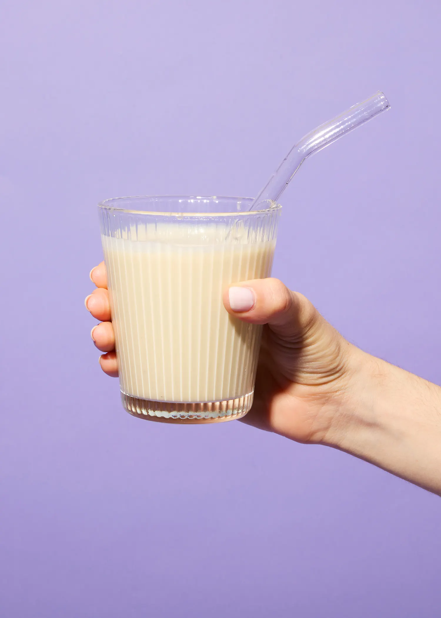 une personne tient un verre de milkshake avec une paille