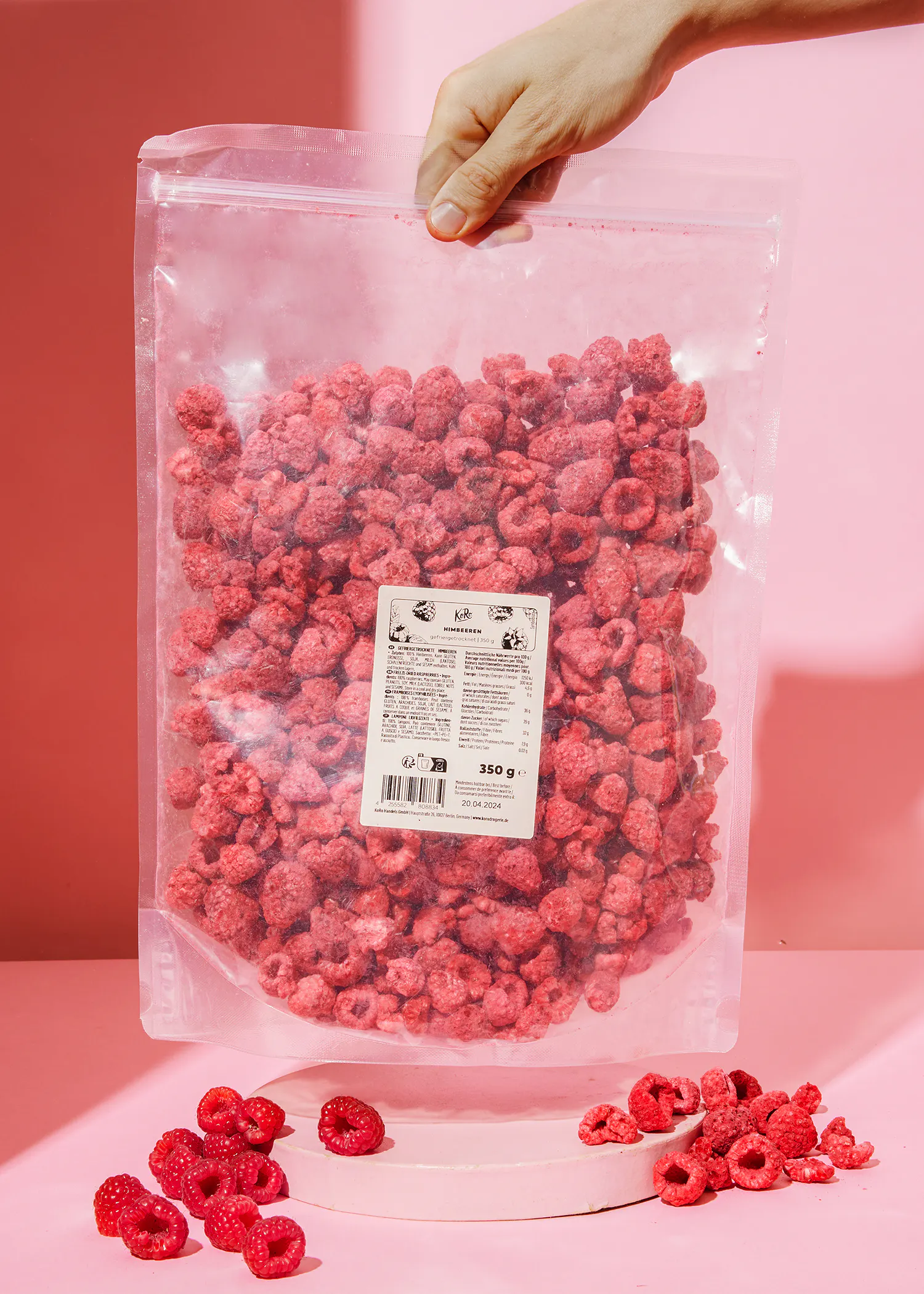 a person is holding a bag of dried raspberries