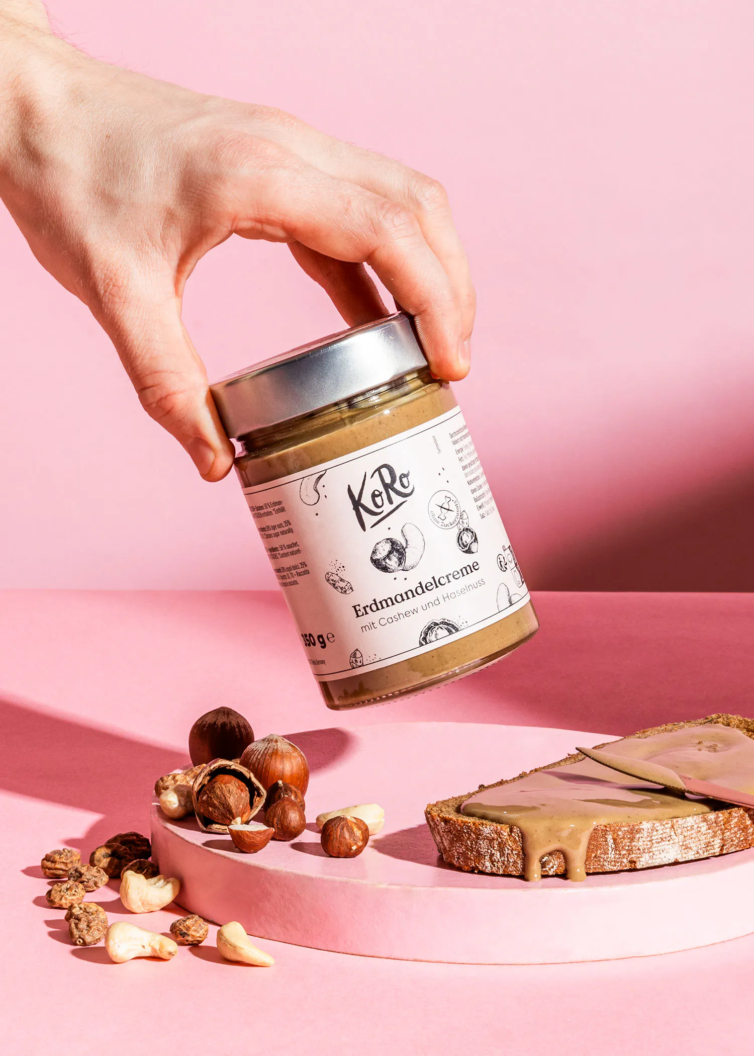 une personne tient une bouteille de crème d' amandes sur une table rose