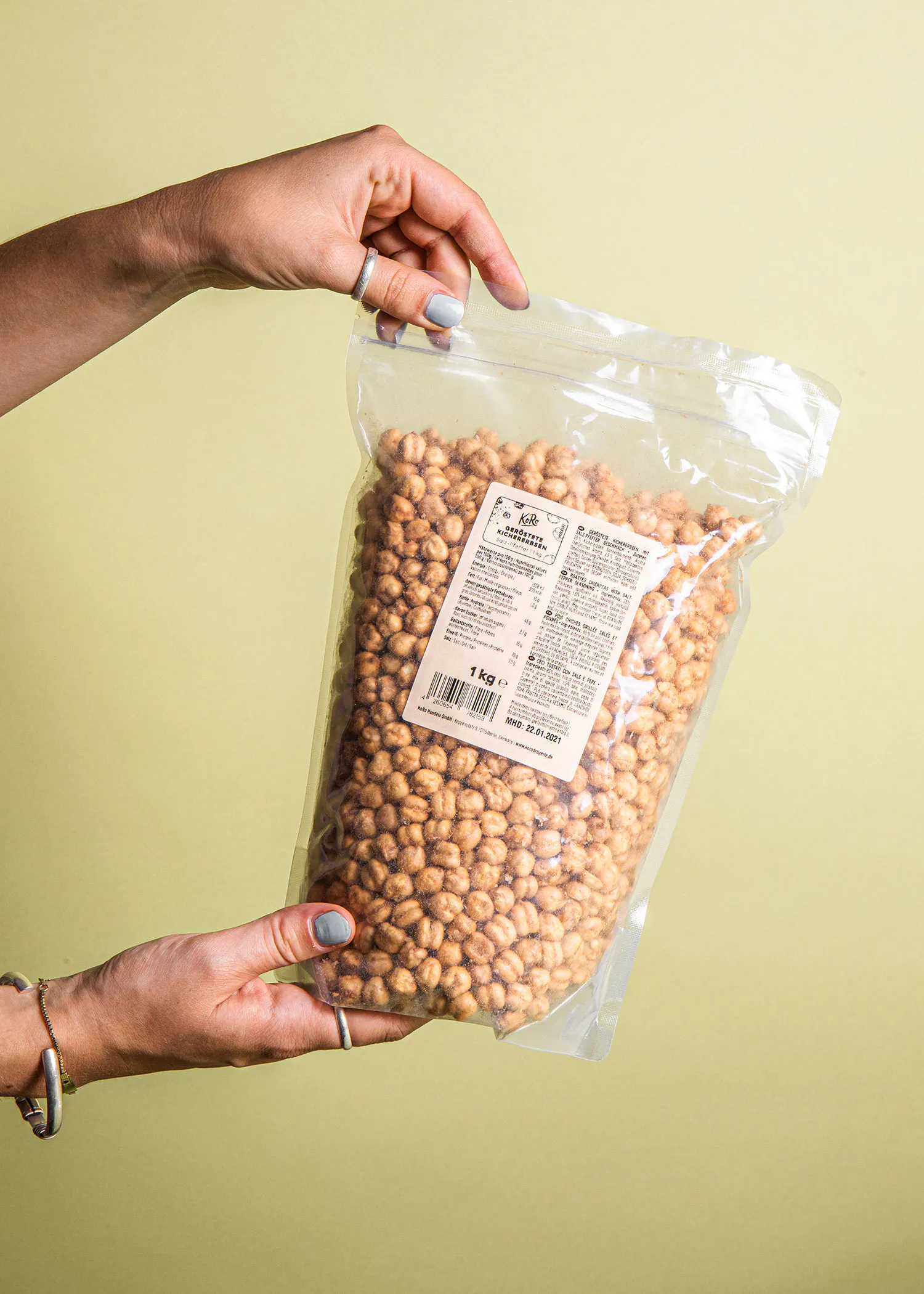 une personne tient un sac en plastique rempli de noisettes