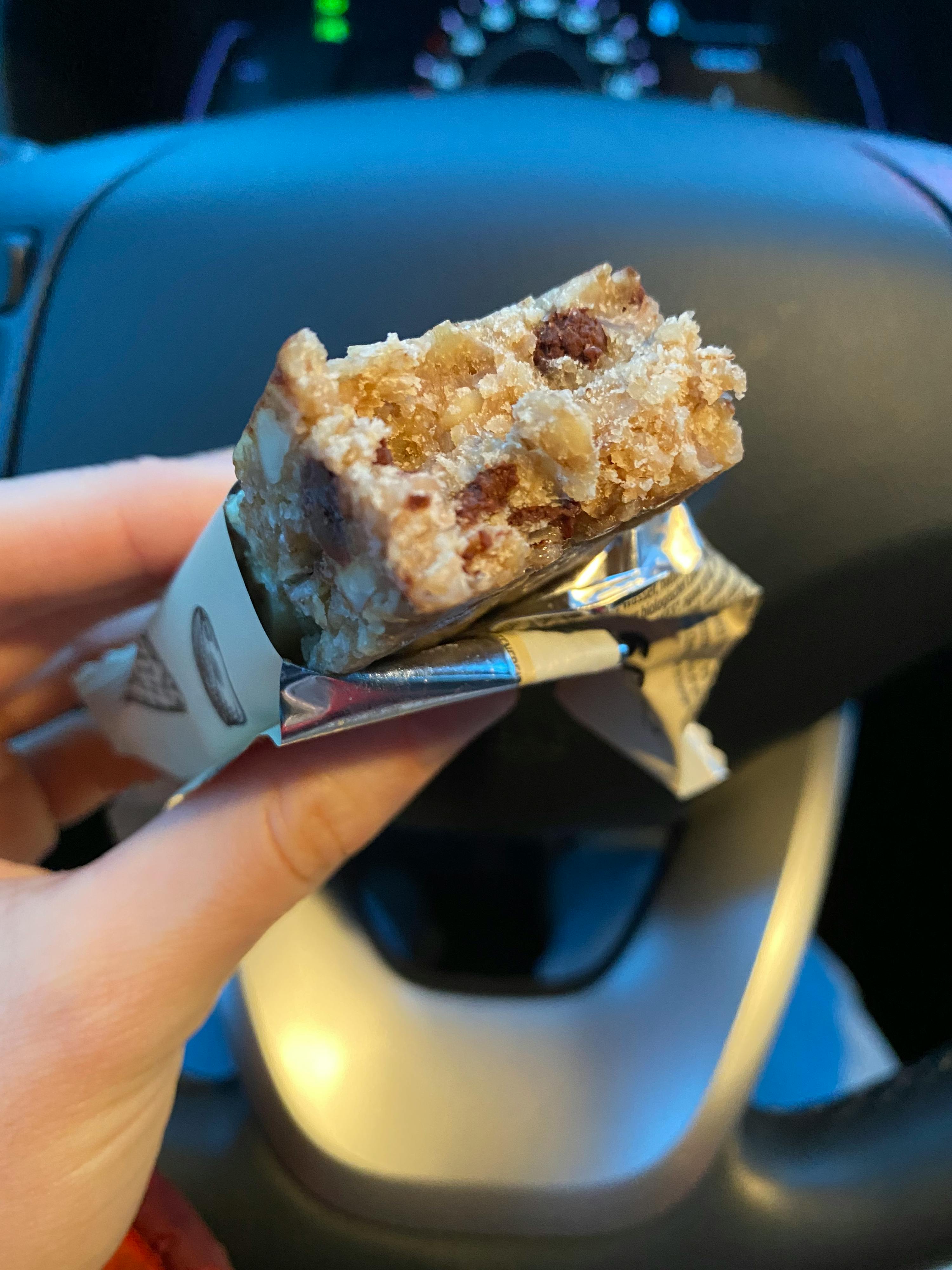 une personne tient une barre de céréales avec un morceau coupé