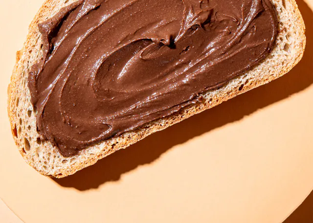 ein Stück Brot mit Schokoladencreme auf einem Teller