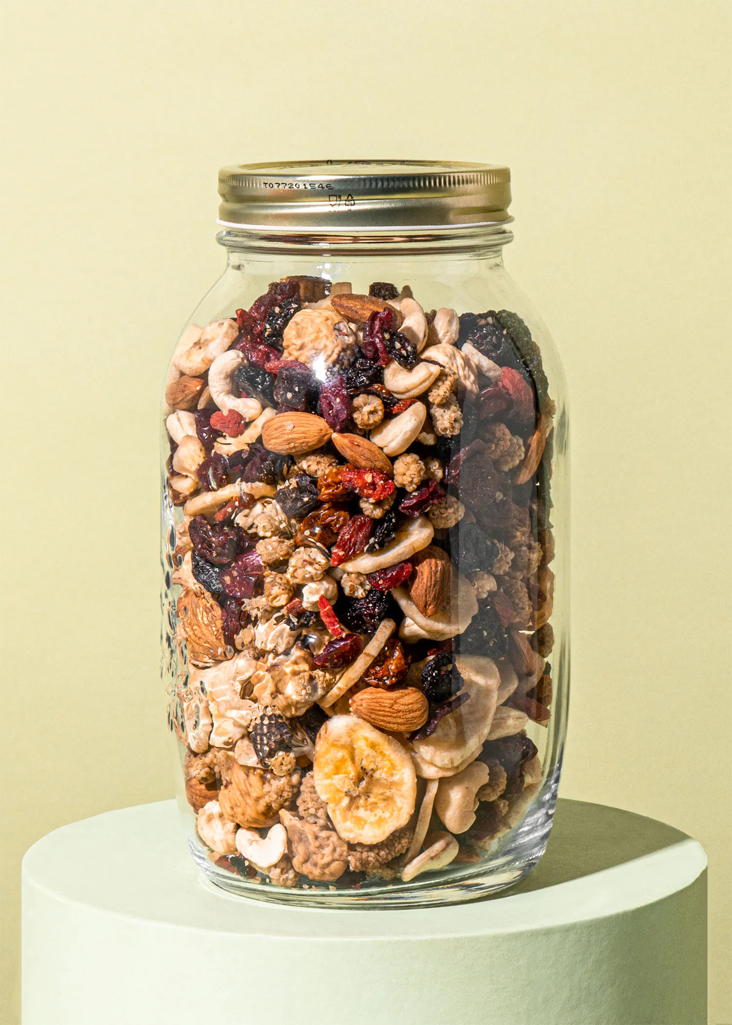 ein Glas voller Nüsse und Trockenfrüchte steht auf einem Ständer