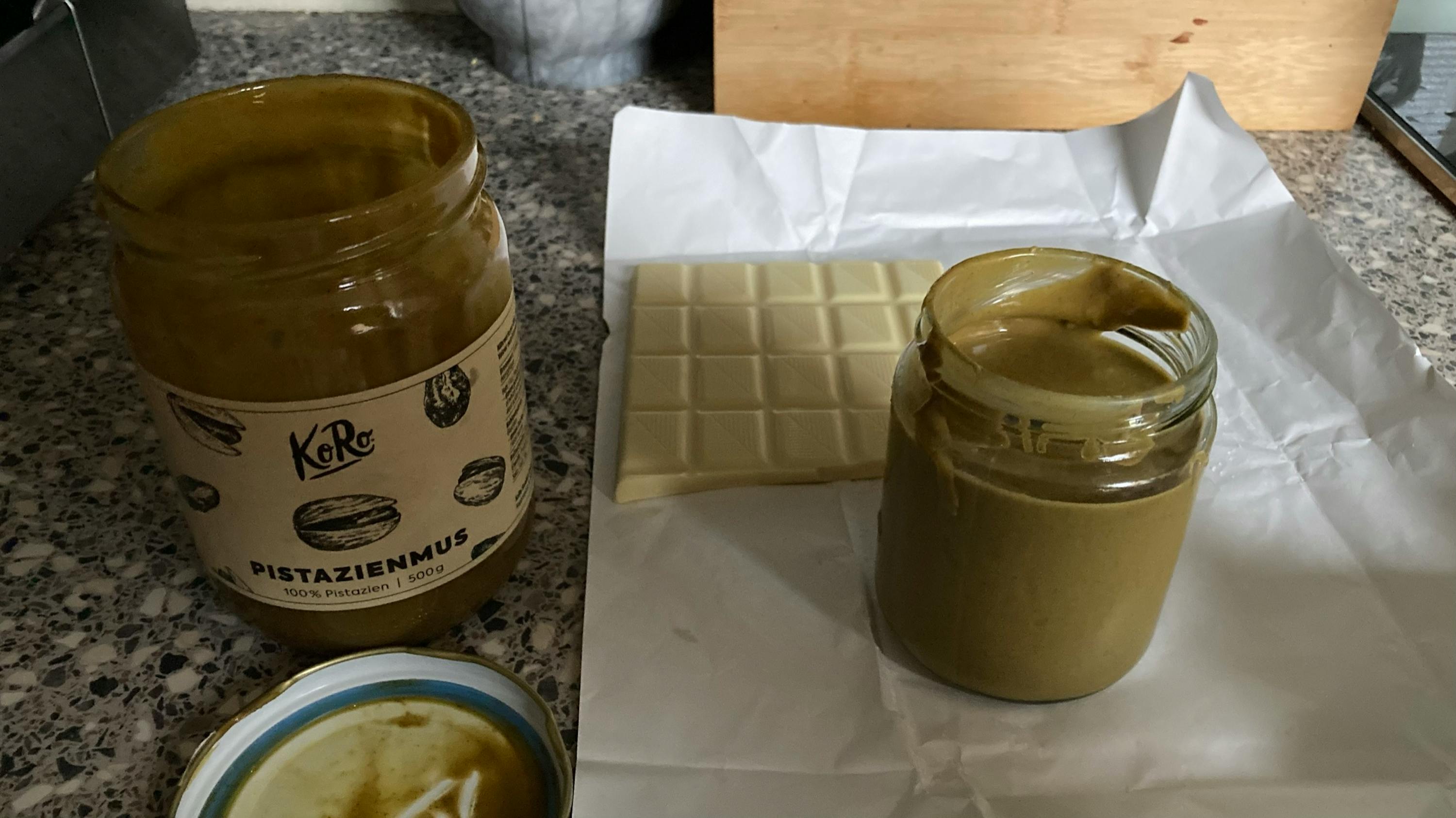 a jar of pistazienmus sits next to a white chocolate bar