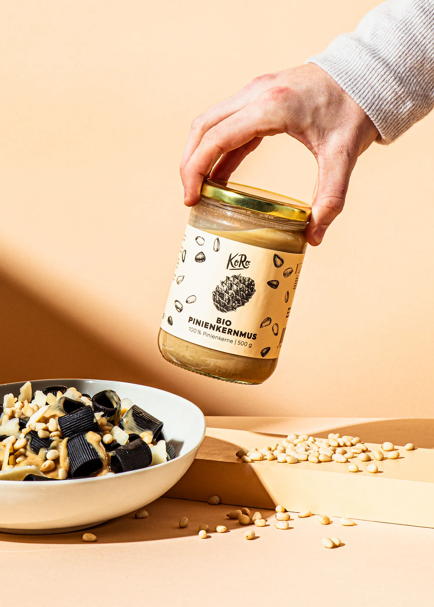 a person is holding a jar of pinienkernmus