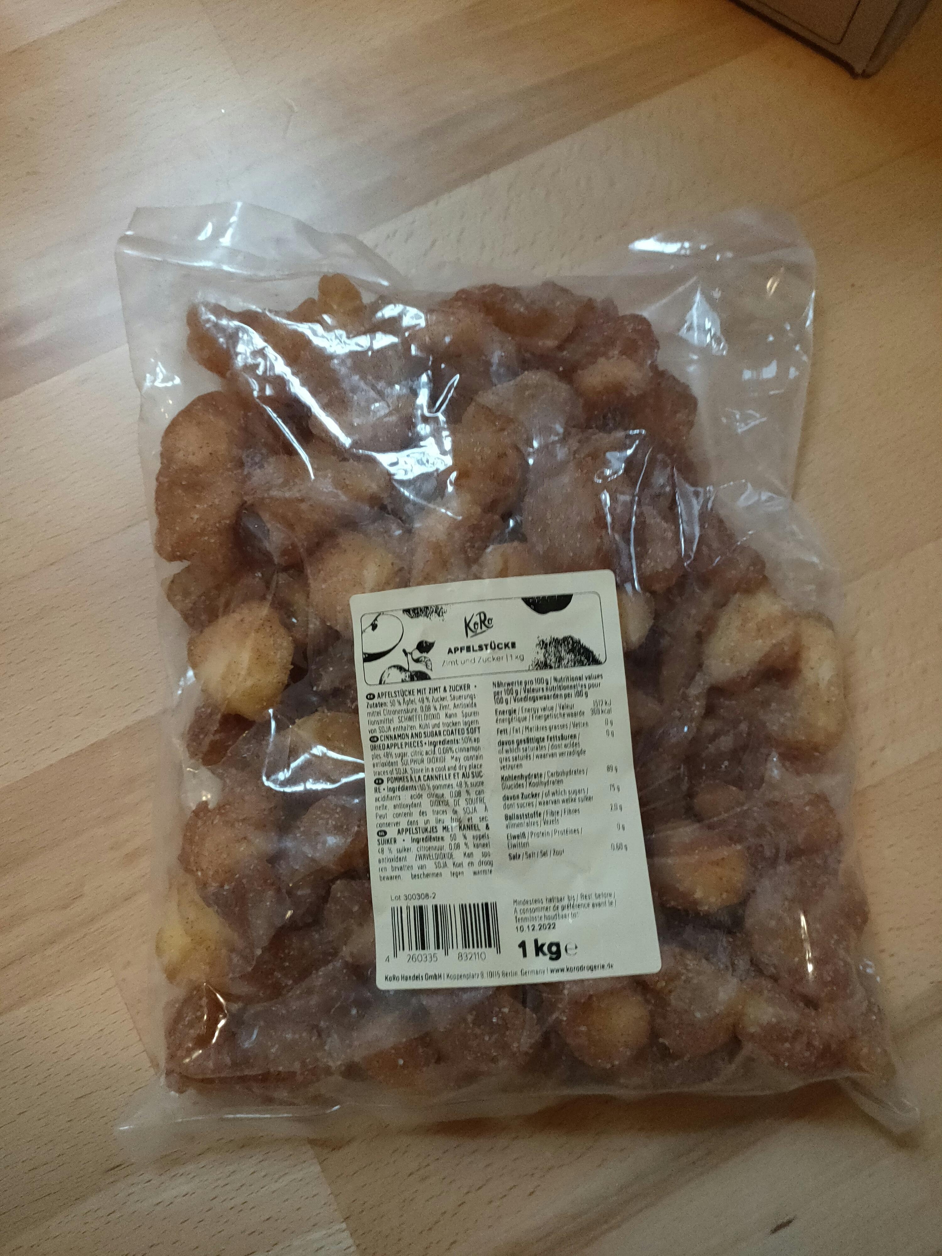 un sac de pommes séchées avec une étiquette blanche sur une table en bois