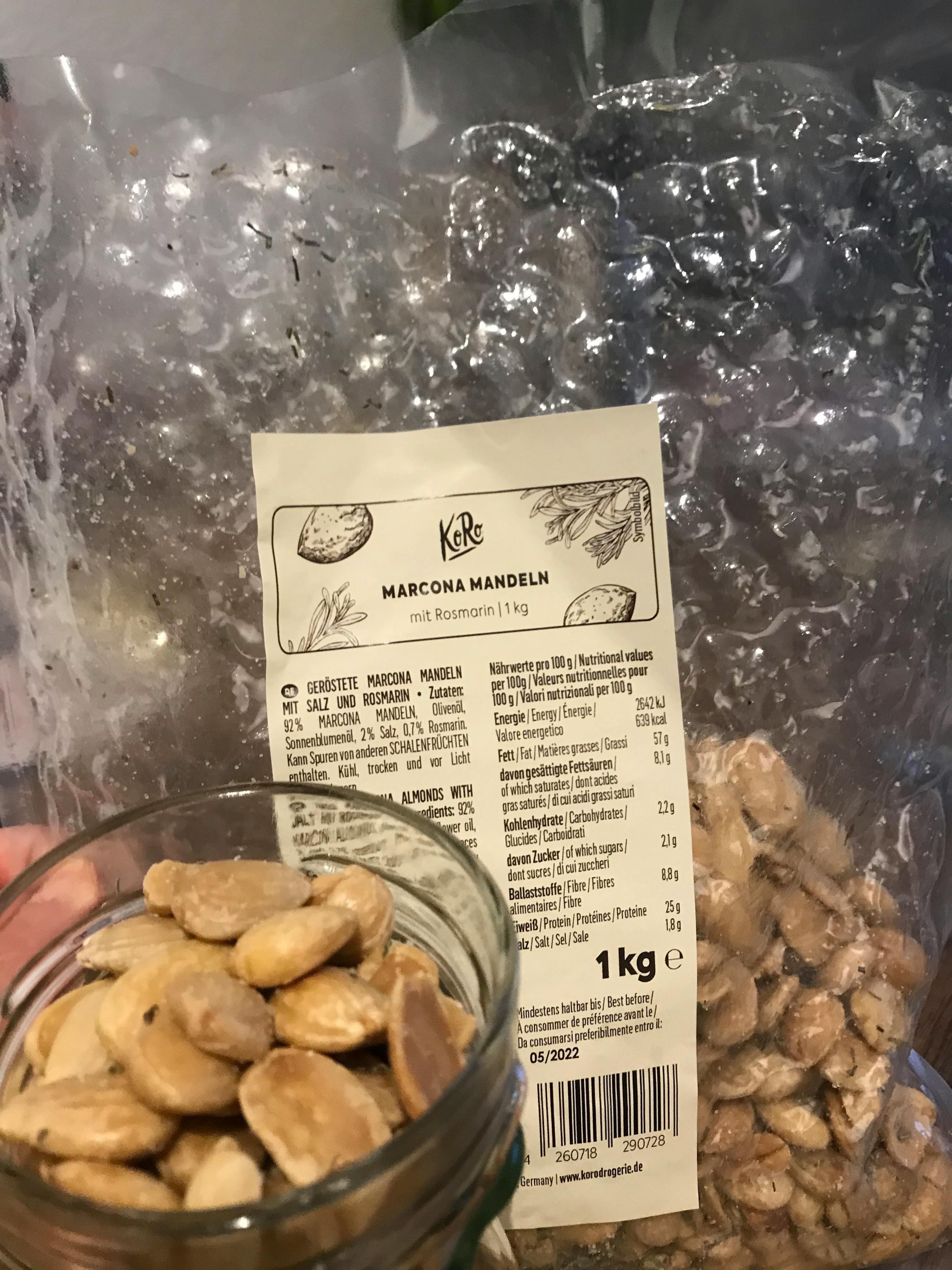 une personne tient une bouteille de marcona mandeln à côté d' un sac