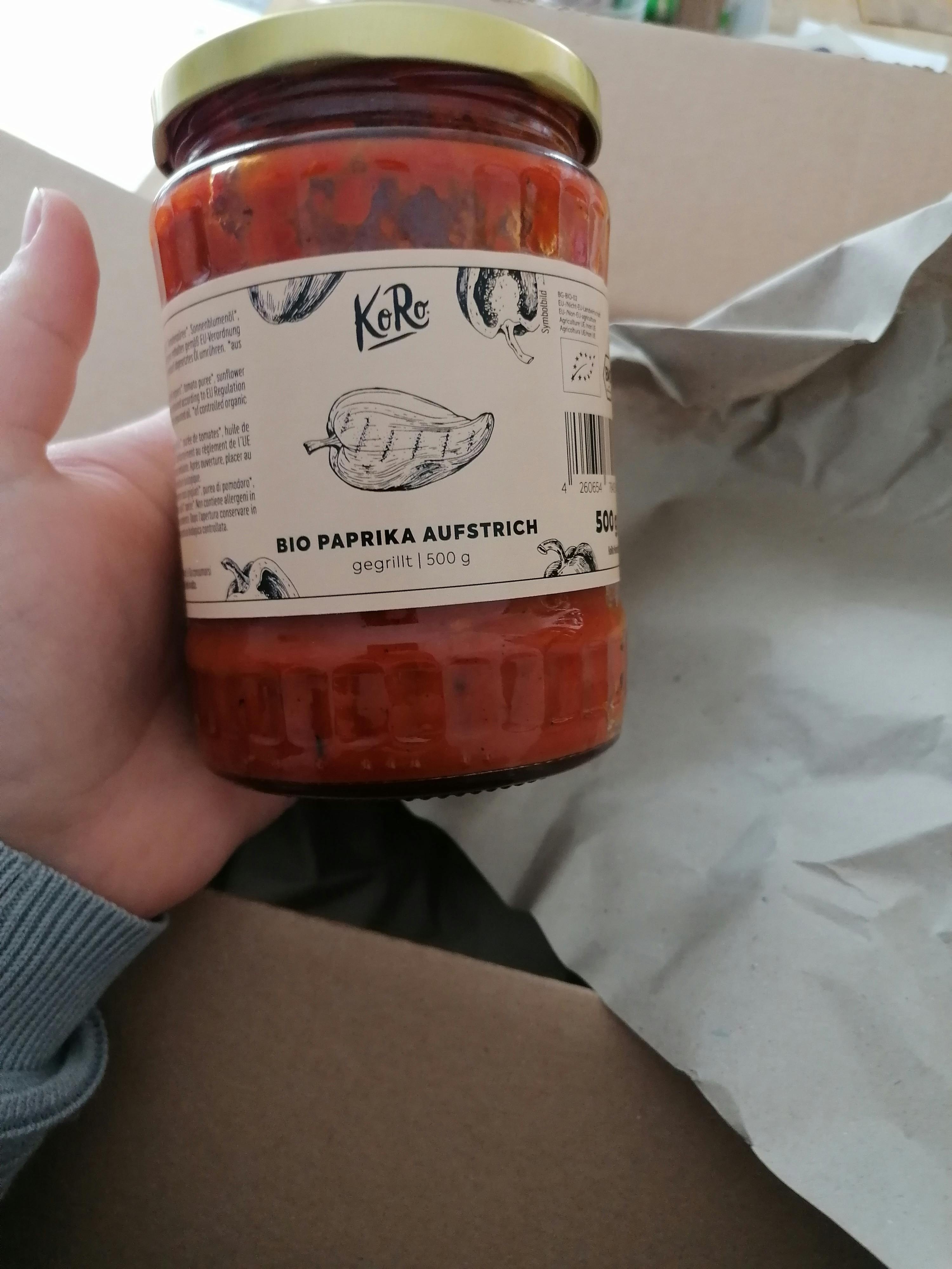 une personne tient un bocal de sauce de paprika bio