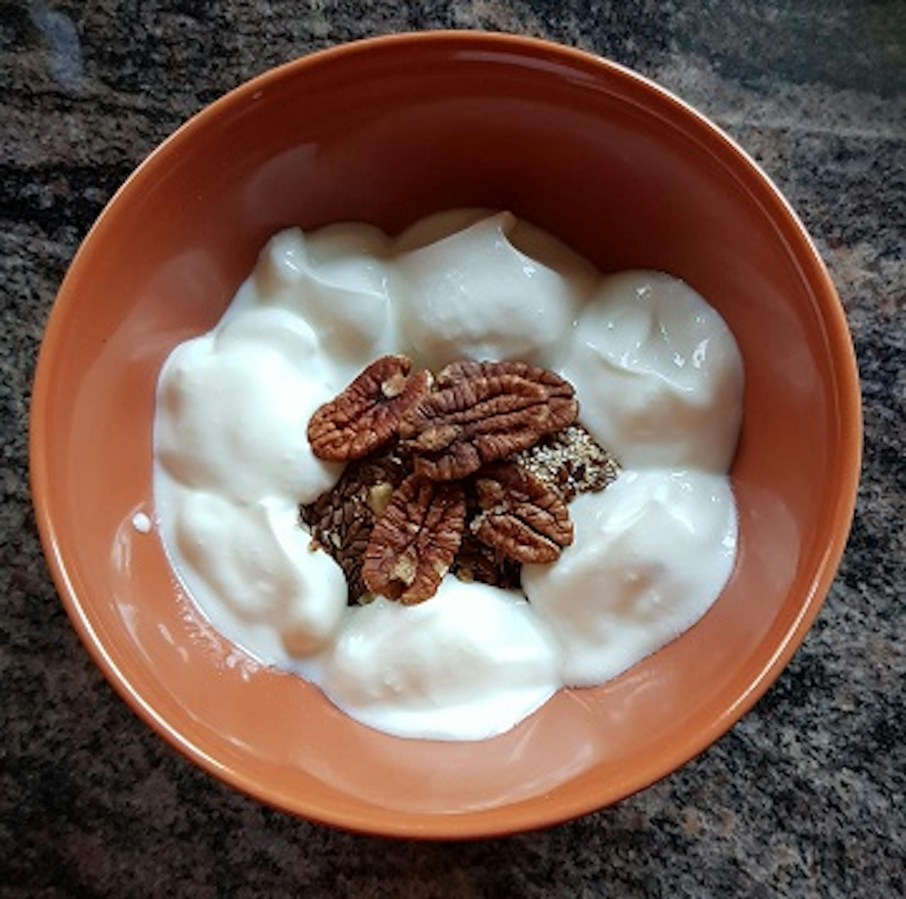 a bowl of yogurt with pecans on top