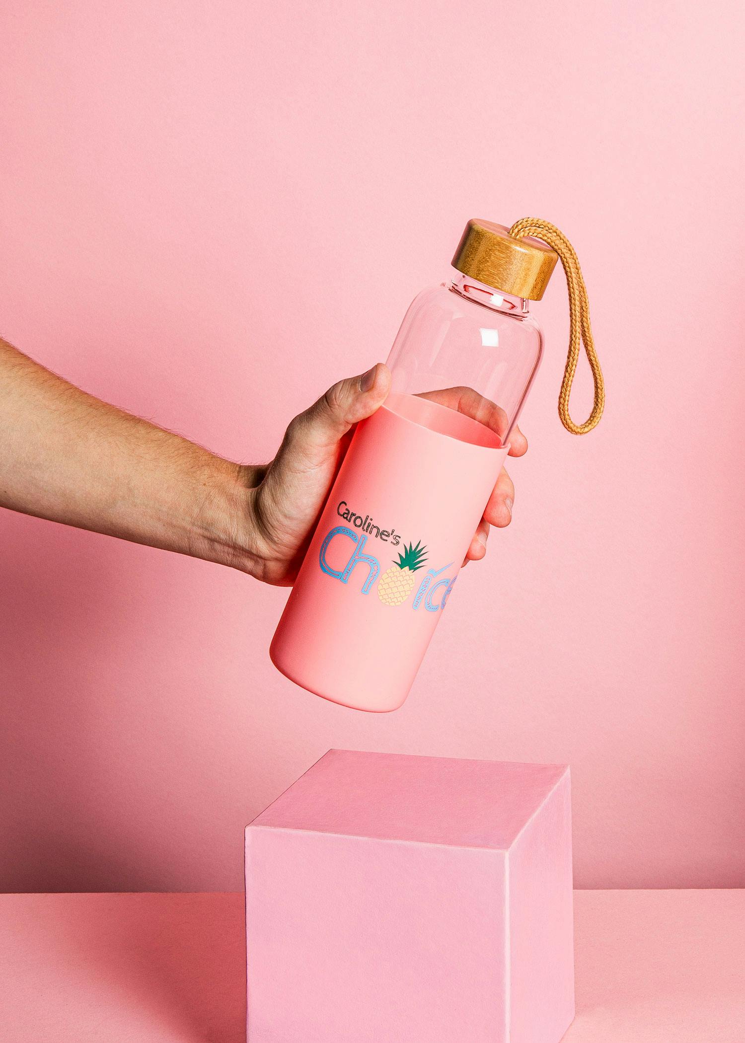 a person is holding a pink water bottle that says caroline 's child