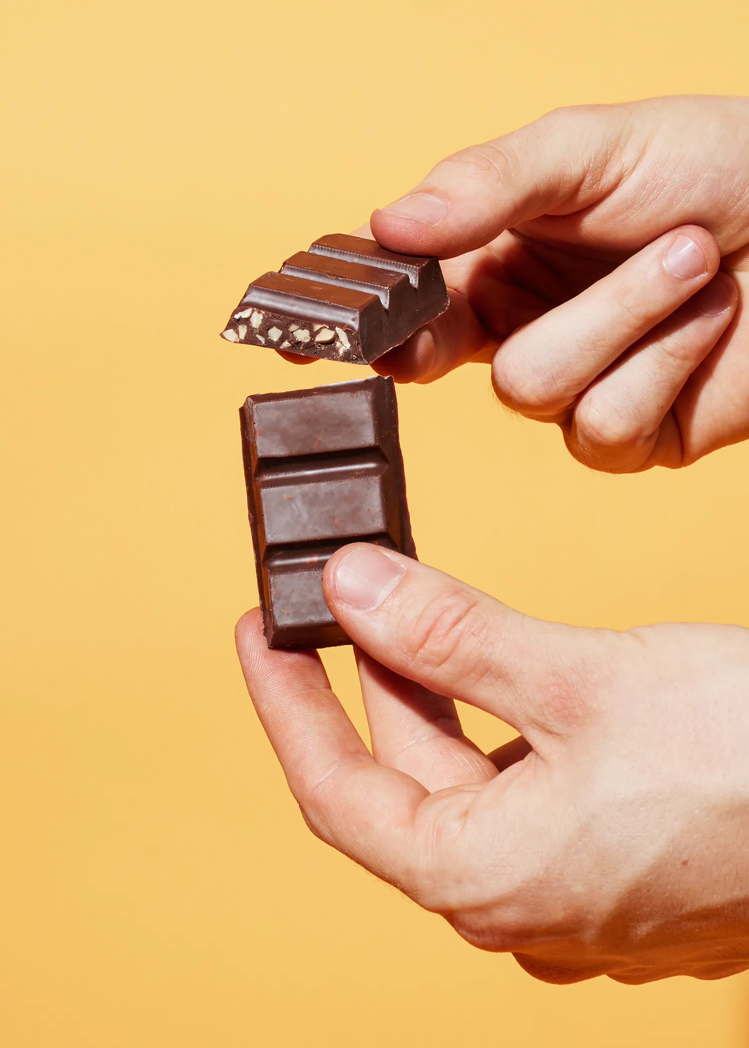 une personne tient une barre de chocolat dans ses mains