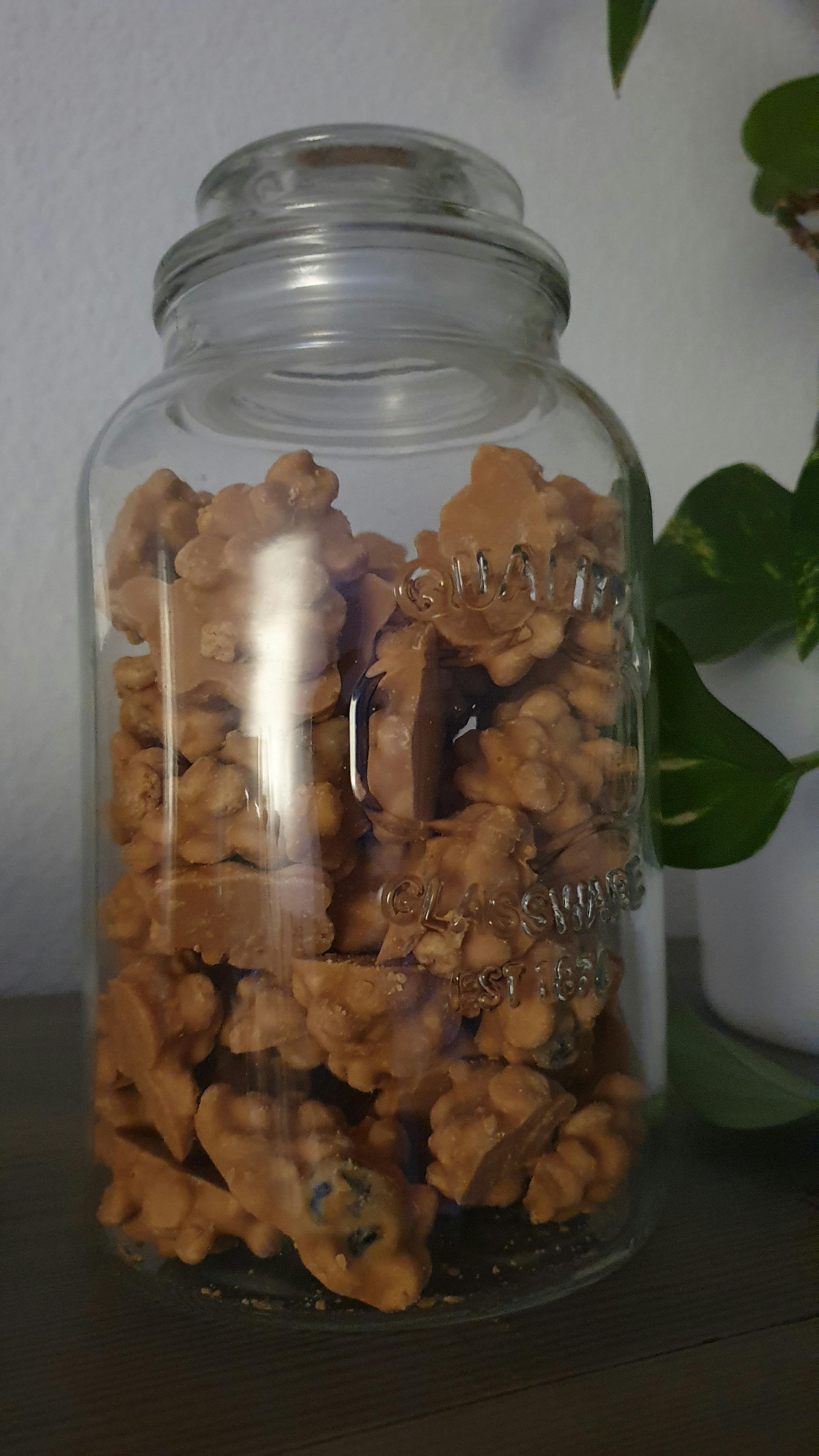 a mason jar filled with peanut butter covered walnuts