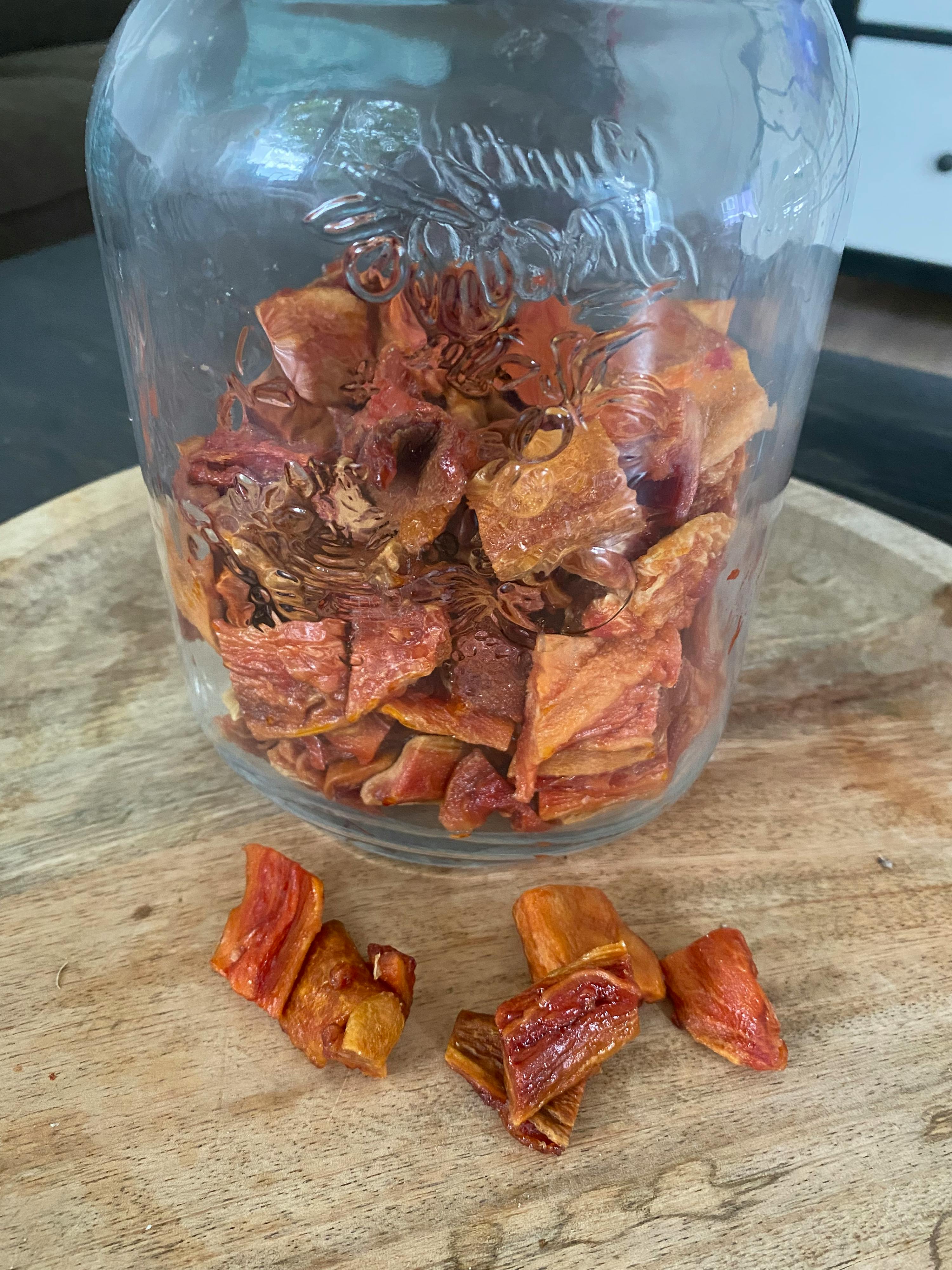 ein Glas mit getrockneten Früchten steht auf einem Holztisch