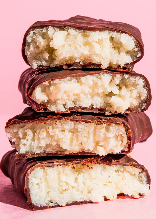 trois barres de chocolat empilées les unes sur les autres sur fond rose