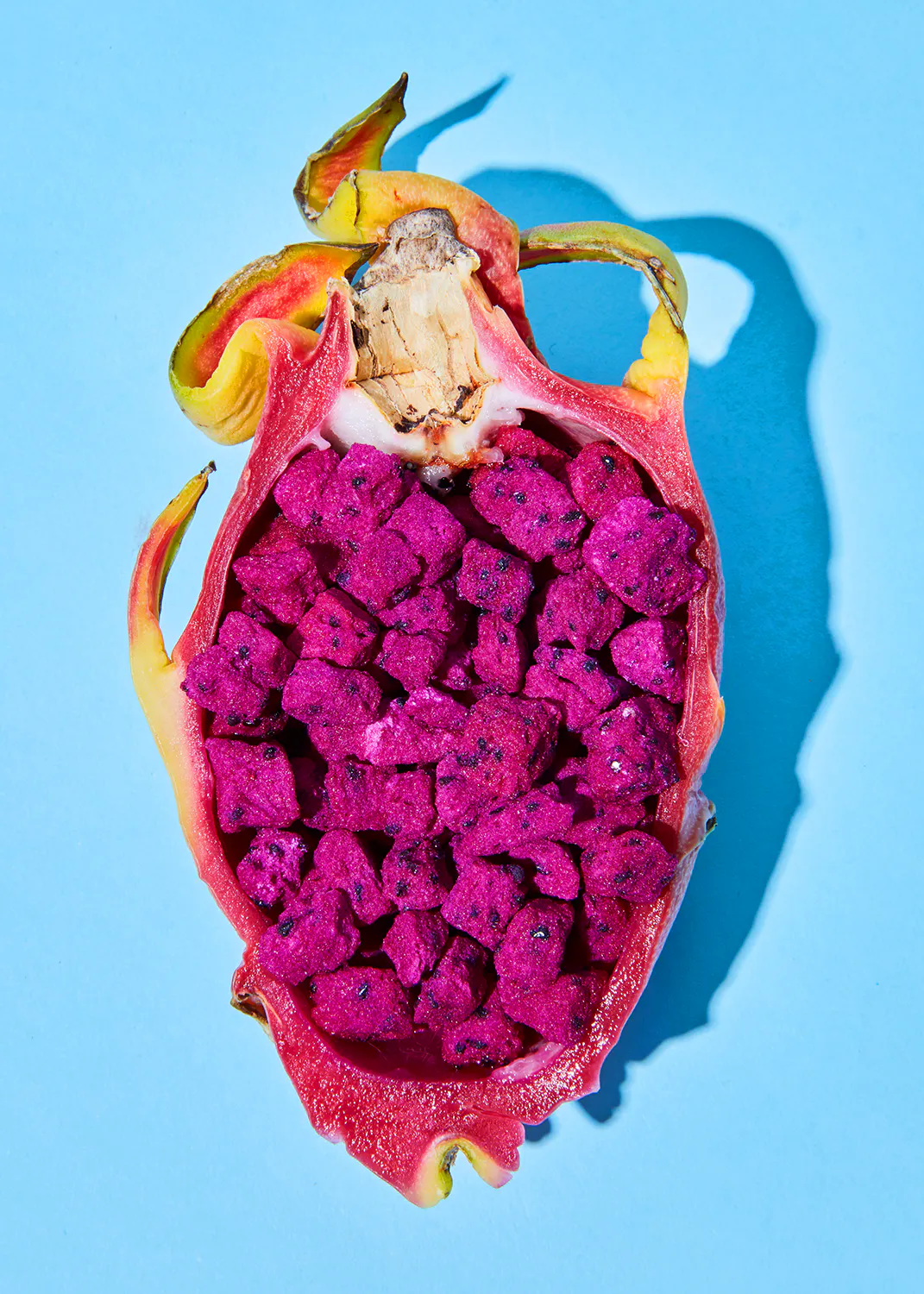 le fruit du dragon est coupé en deux et recouvert de graines violettes