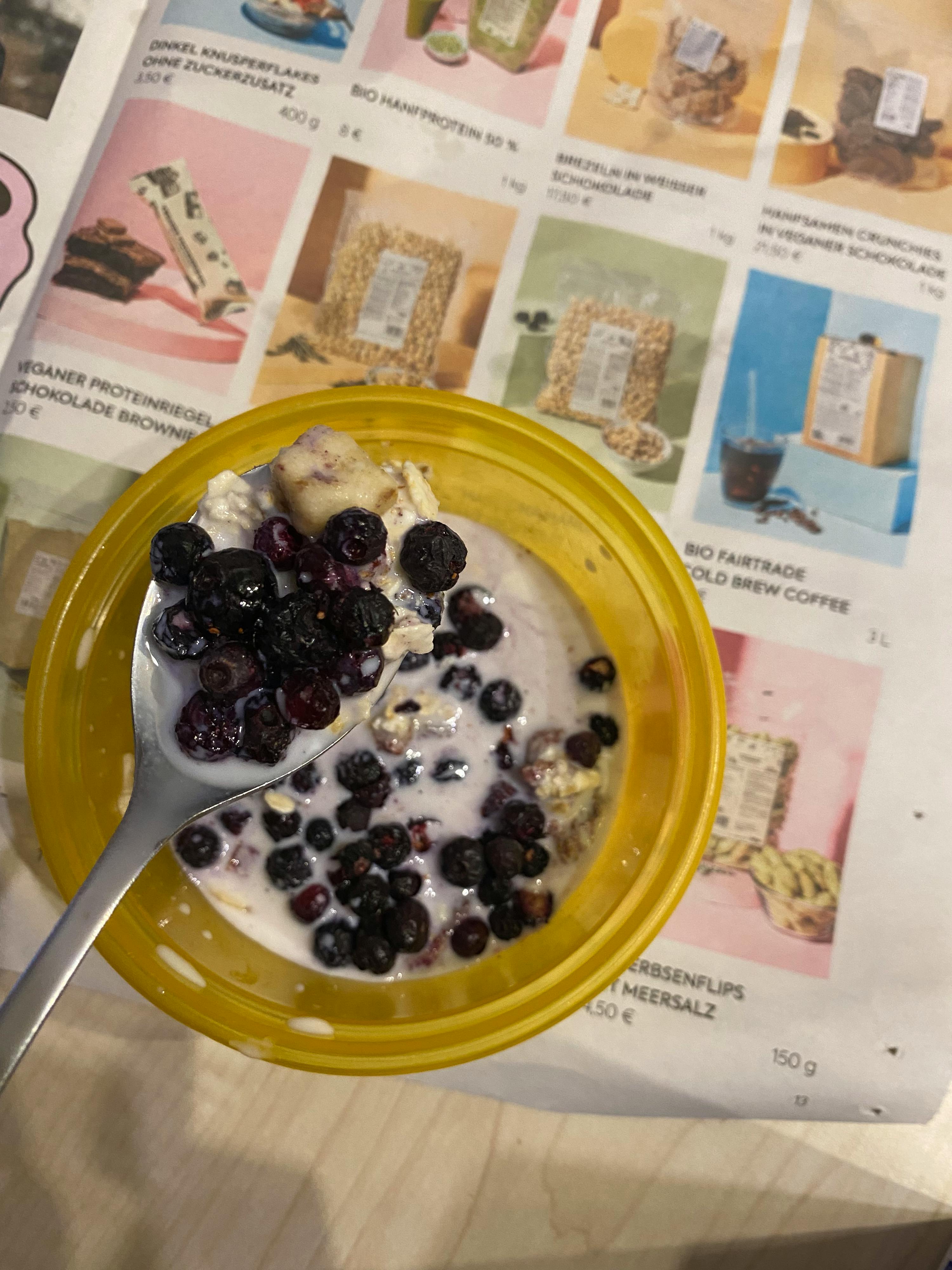 un bol jaune rempli d' avoine et de myrtilles sur une cuillère