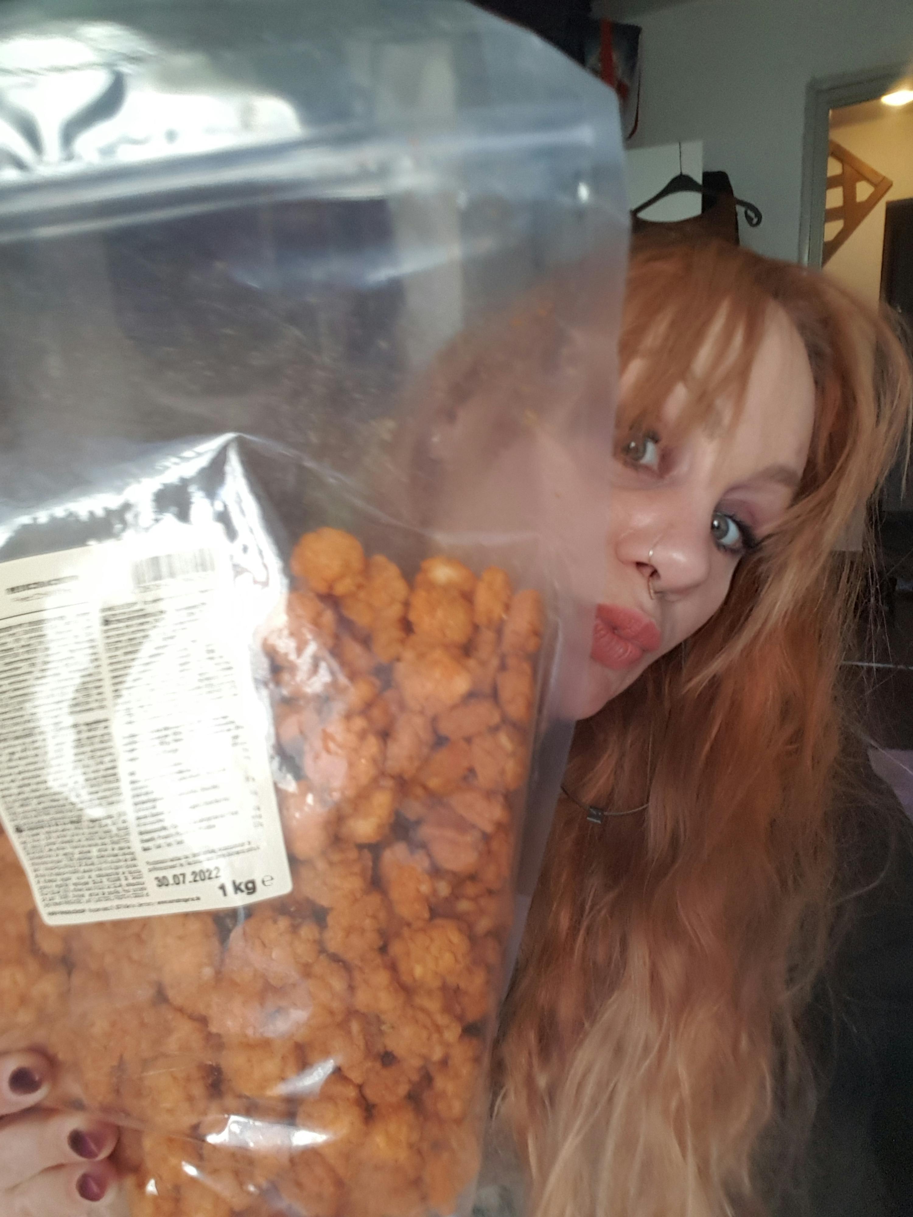 une femme se tient à côté d' un sac de popcorn