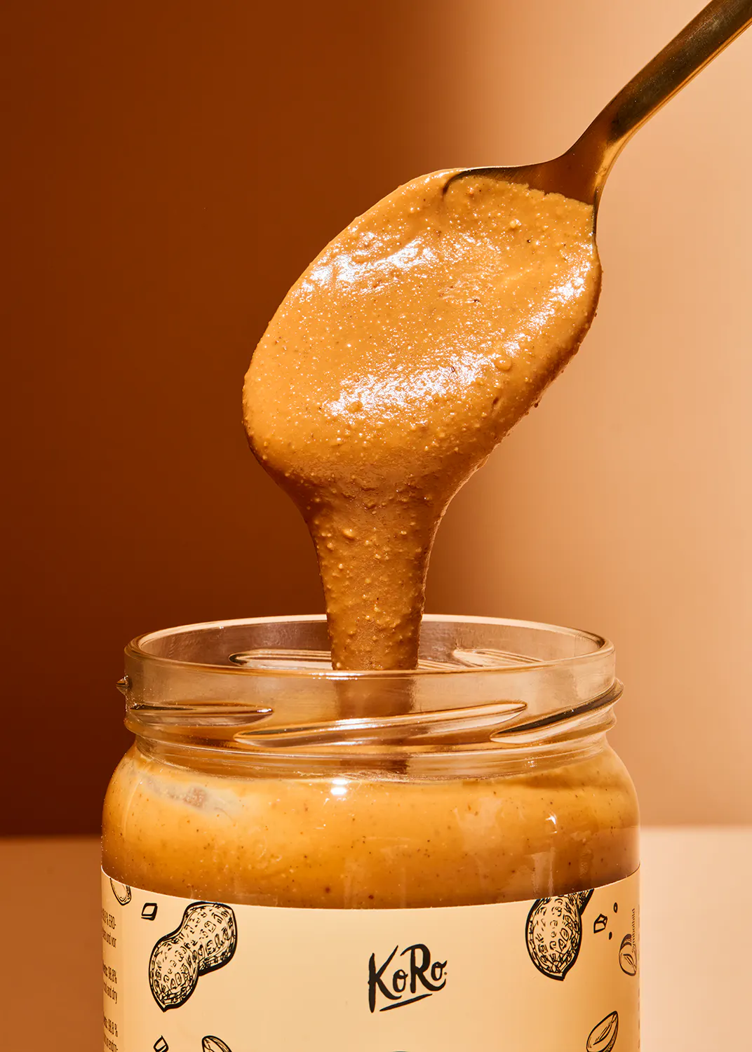 une cuillère de beurre d' arachide est versée dans un bocal