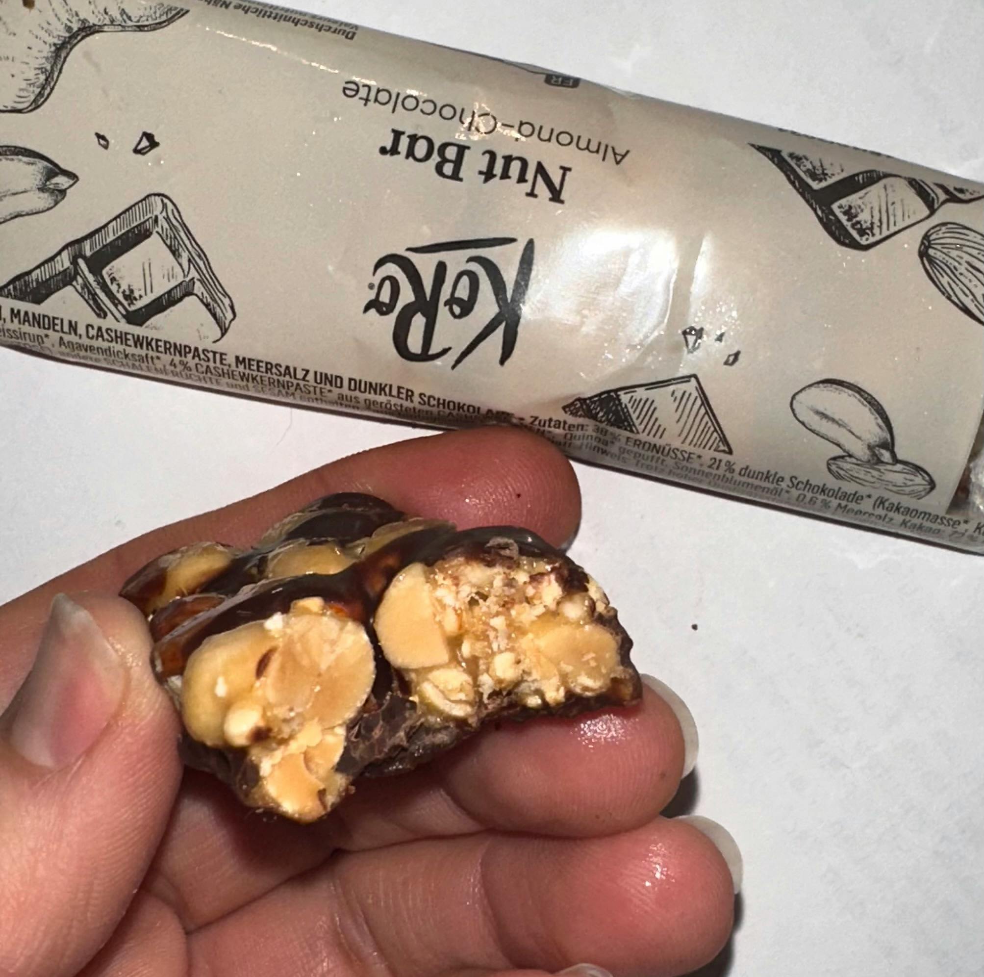 eine Person hält eine Nuss-Schokolade-Bar in der Hand