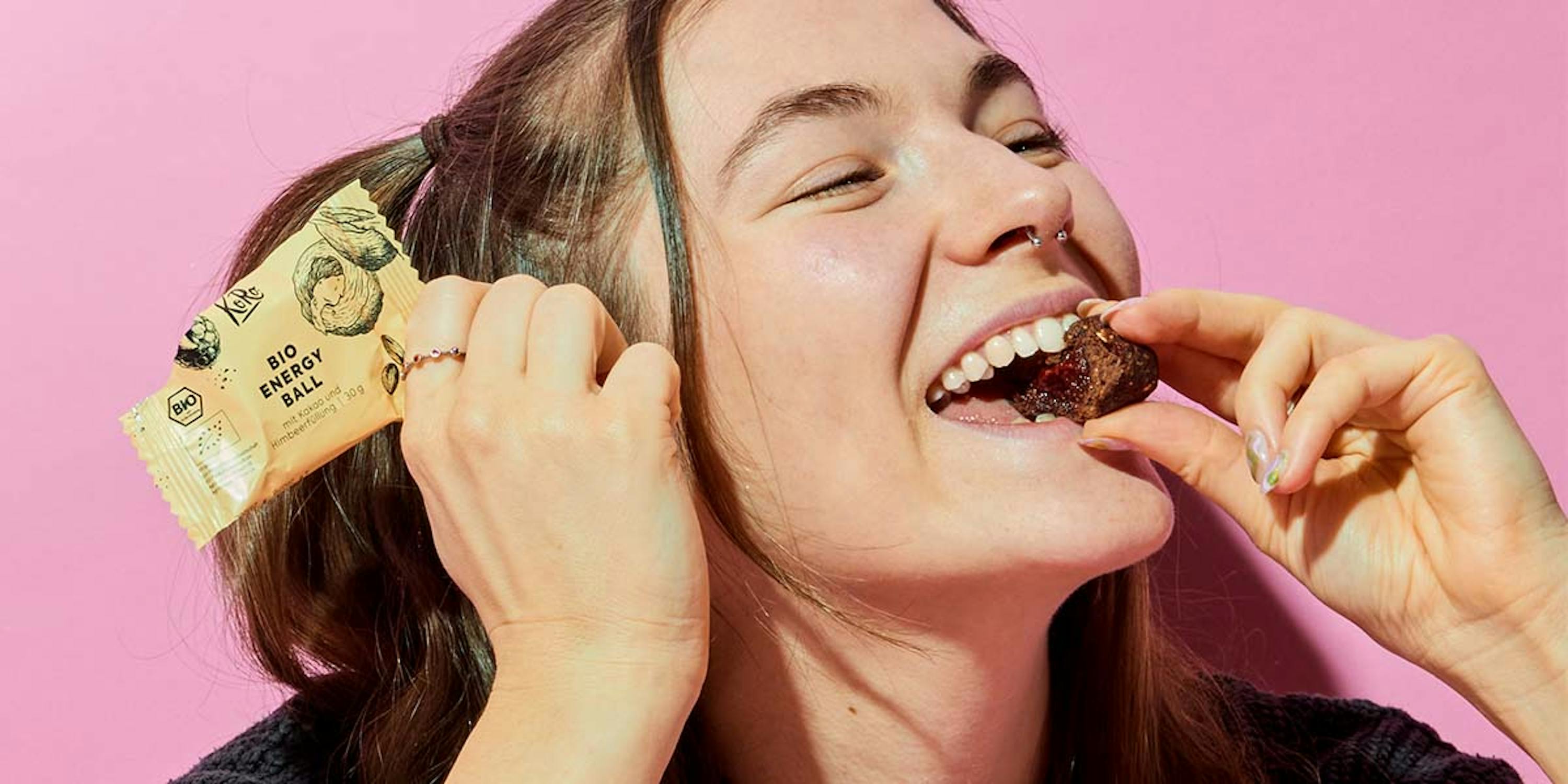 eine frau isst einen bio-energieball