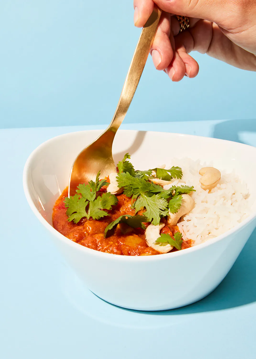 une personne tient une cuillère au-dessus d' un bol de nourriture